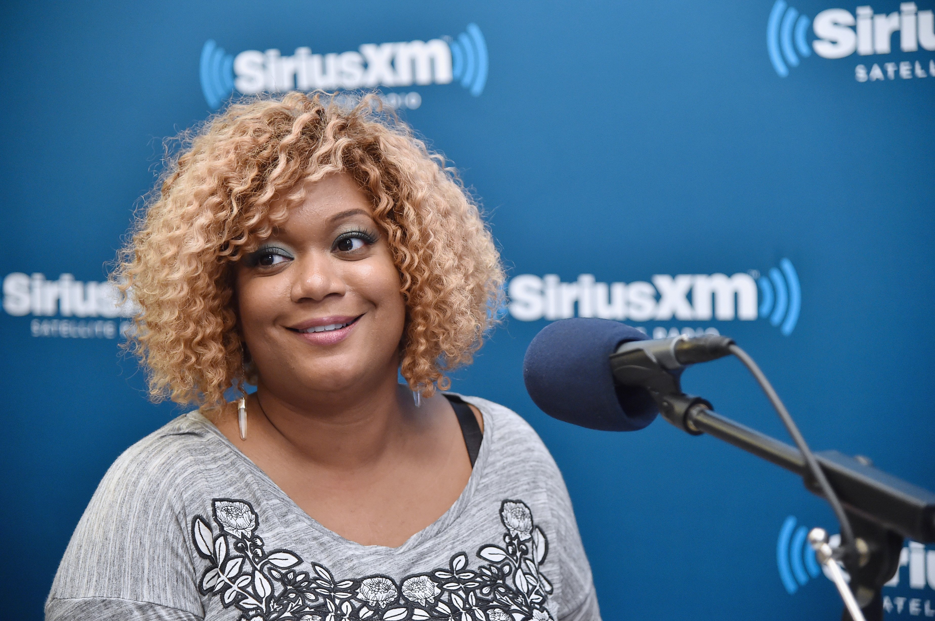 Food Network personality Sunny Anderson wears a gray T-shirt in this photograph.
