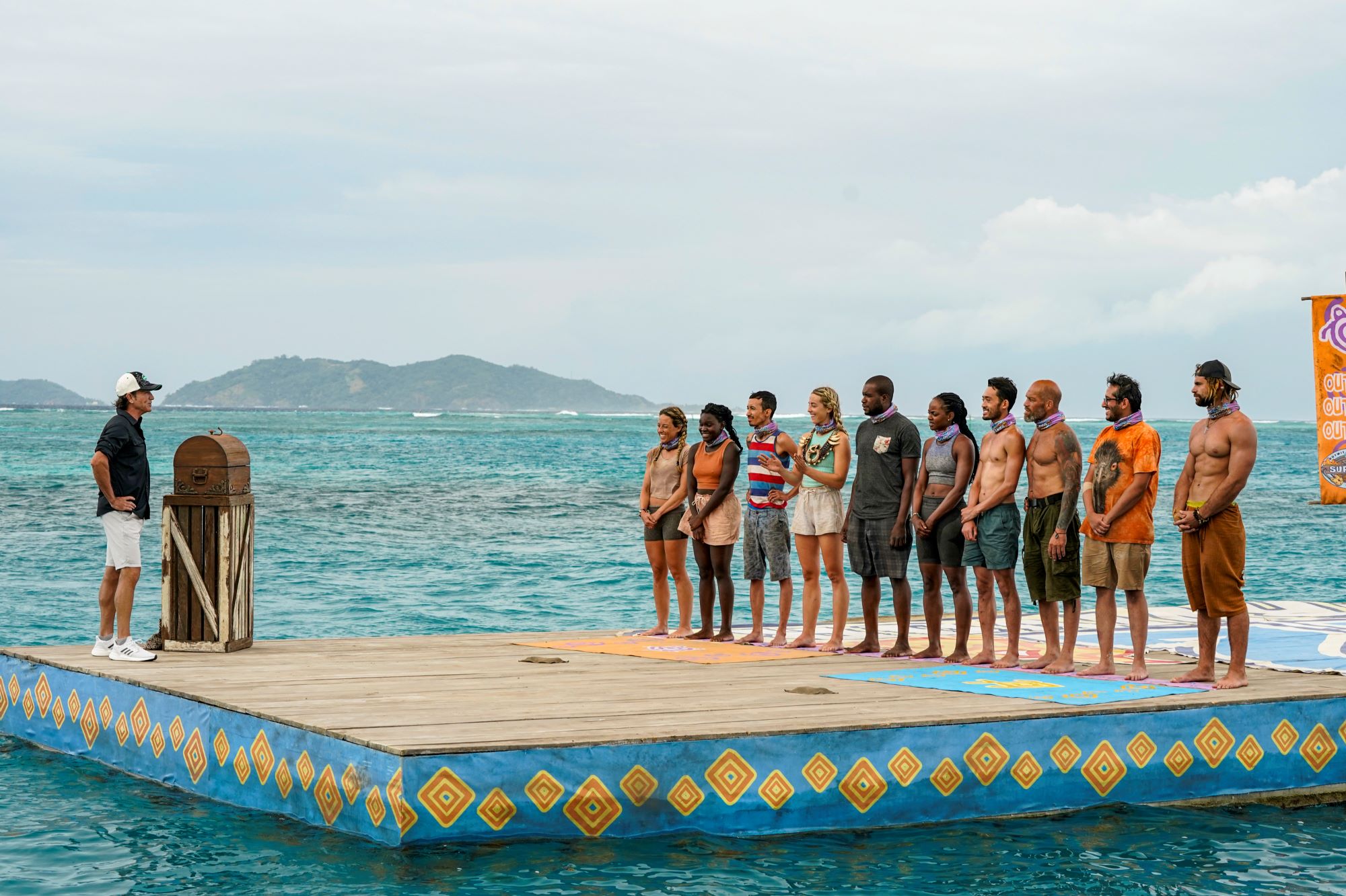 The 'Survivor' Season 42 cast gathers on a platform in the ocean while listening to Jeff Probst explain a challenge.