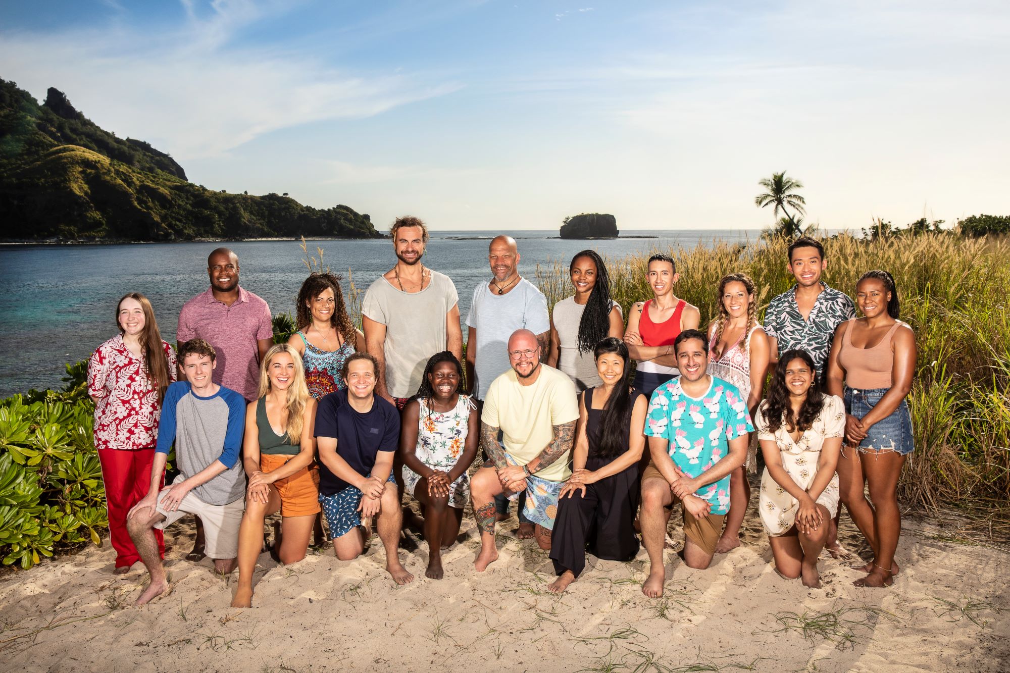 The 'Survivor' Season 42 cast poses for promotional pictures on the beach before the game and spoilers begin. Ten castaways stand in the back row, and the other eight kneel in the front row.