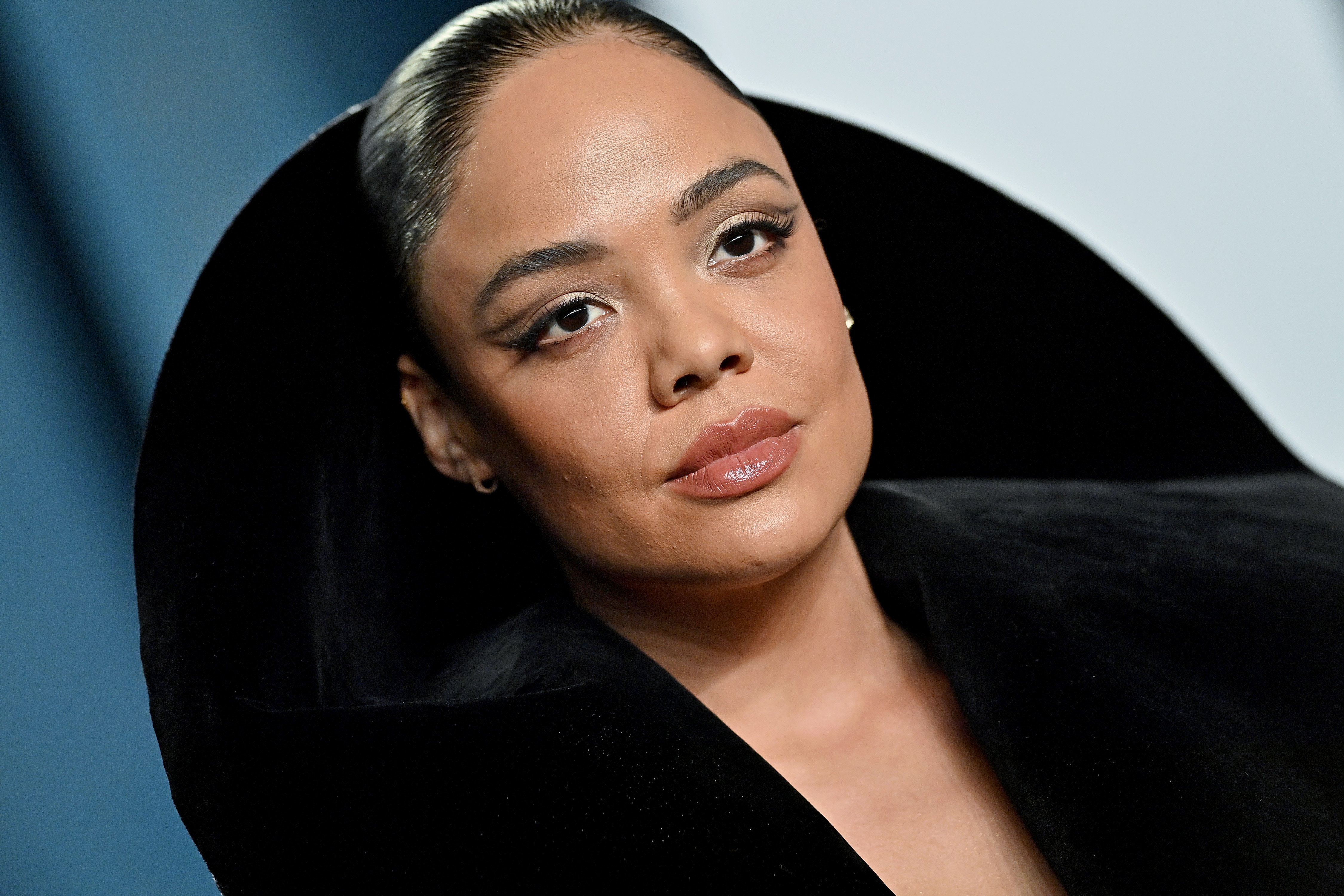 Tessa Thompson, who plays Valkyrie, not a villain, in 'Thor: Love and Thunder,' wears a black suit with a hood that sticks up behind her head.