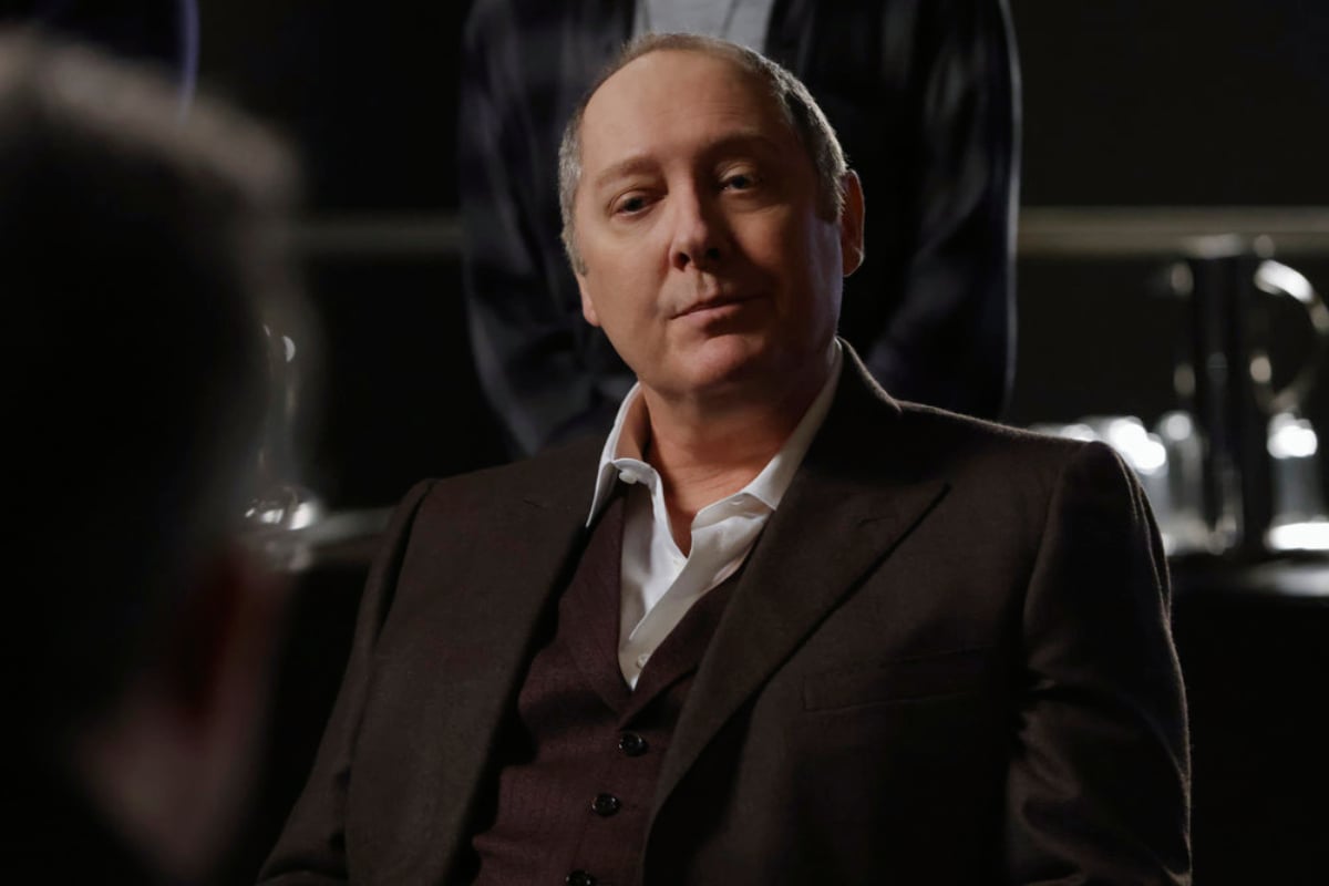 James Spader as Raymond Reddington in The Blacklist Season 9. Red is wearing a suit and sitting in a chair.