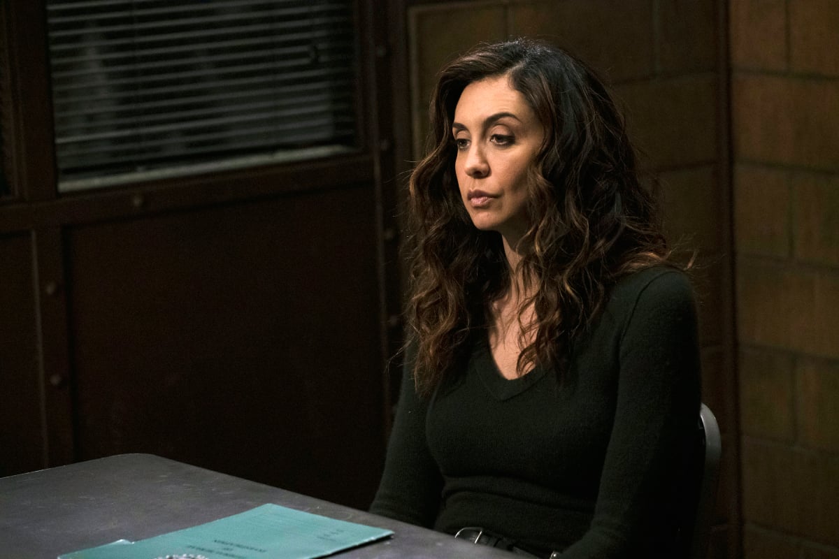 Mozhan Marnò as Samar Navabi in The Blacklist. Samar sits at a desk wearing a black shirt. 