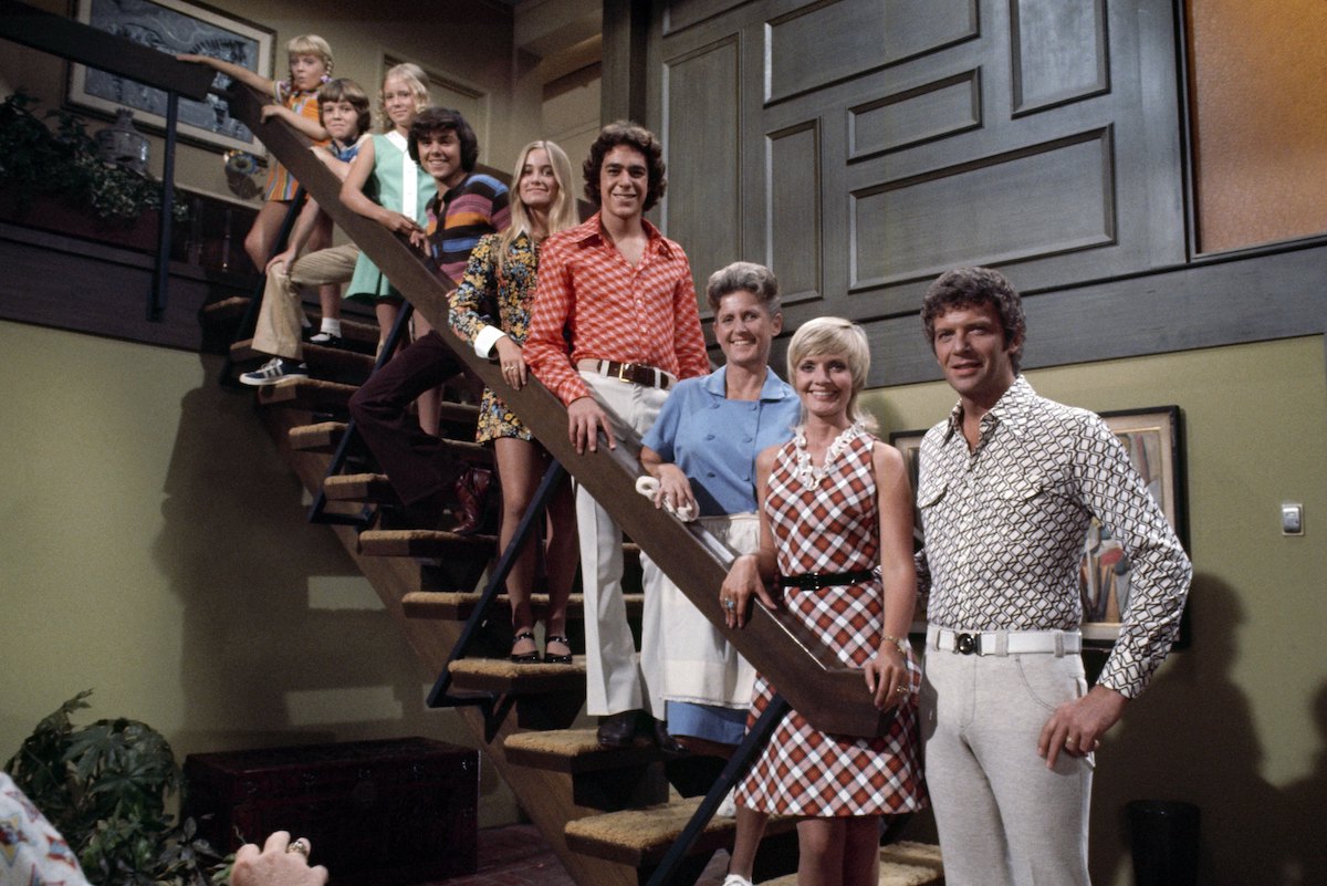 'The Brady Bunch' cast smiling, posed on a staircase