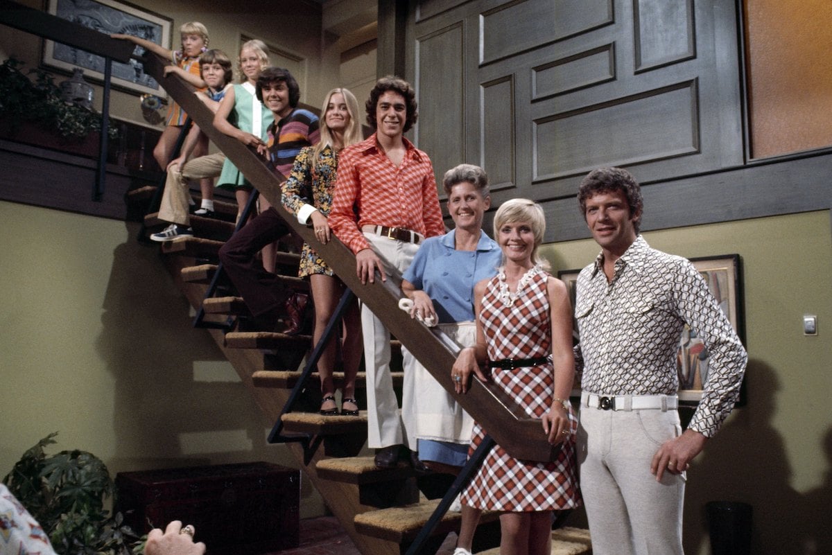 'The Brady Bunch' cast smiling, posed on a staircase