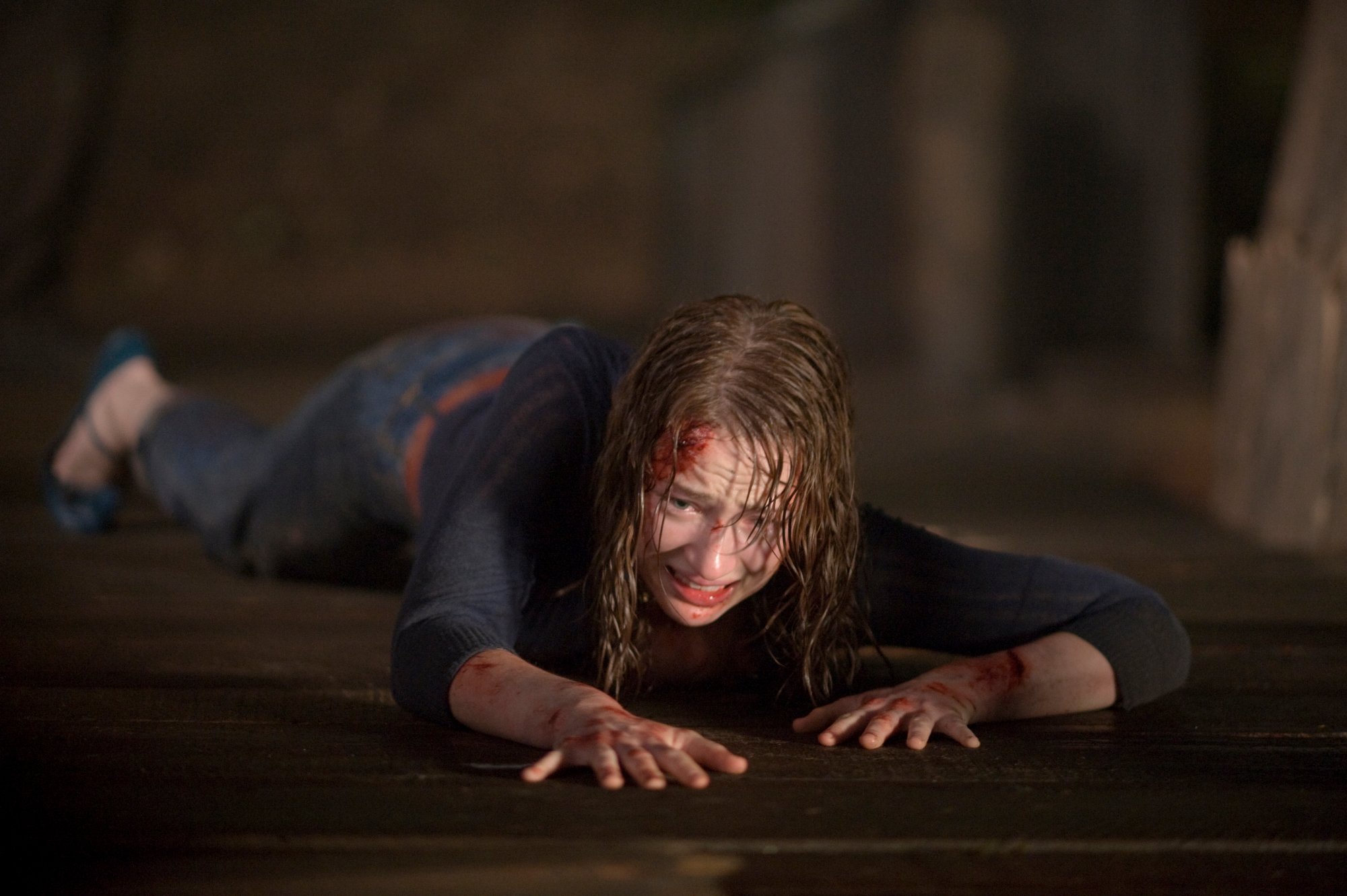 Kristen Connolly stars as 'Dana' in THE CABIN IN THE WOODS. crawling on the floor with blood coming from her head