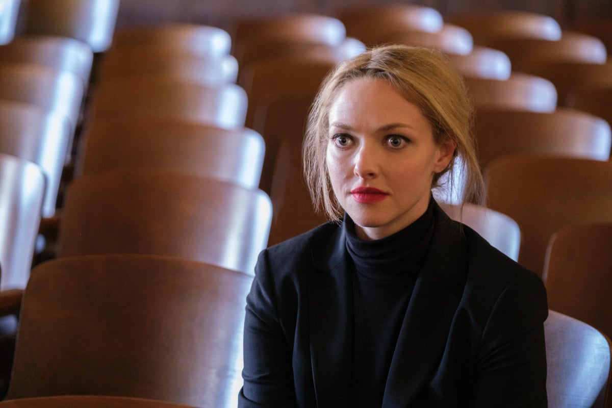 Amanda Seyfried as Elizabeth Holmes in The Dropout. Holmes stares, wearing a black turtleneck.