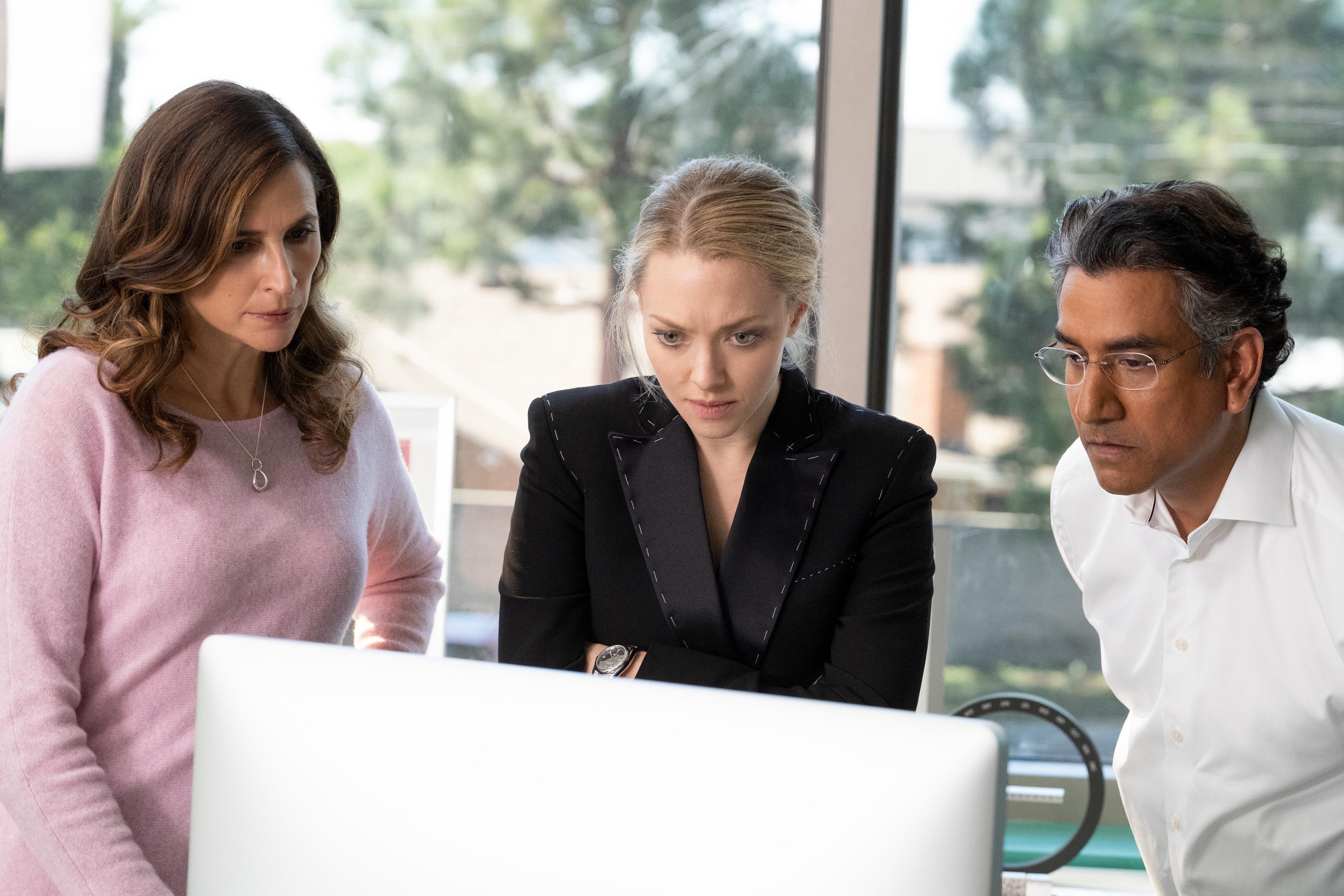 'The Dropout' Episode 8 Michaela Watkins, Amanda Seyfried, and Naveen Andrews looking at a computer screen as Linda Tanner, Elizabeth Holmes, and Sunny Balwani