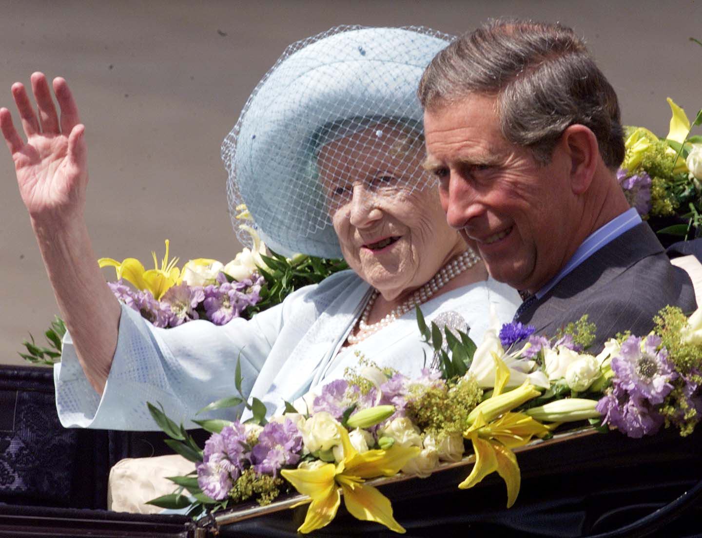The Queen Mother waves alongside Prince Charles as she arrives at Buckingham Palace on her 100th birthday