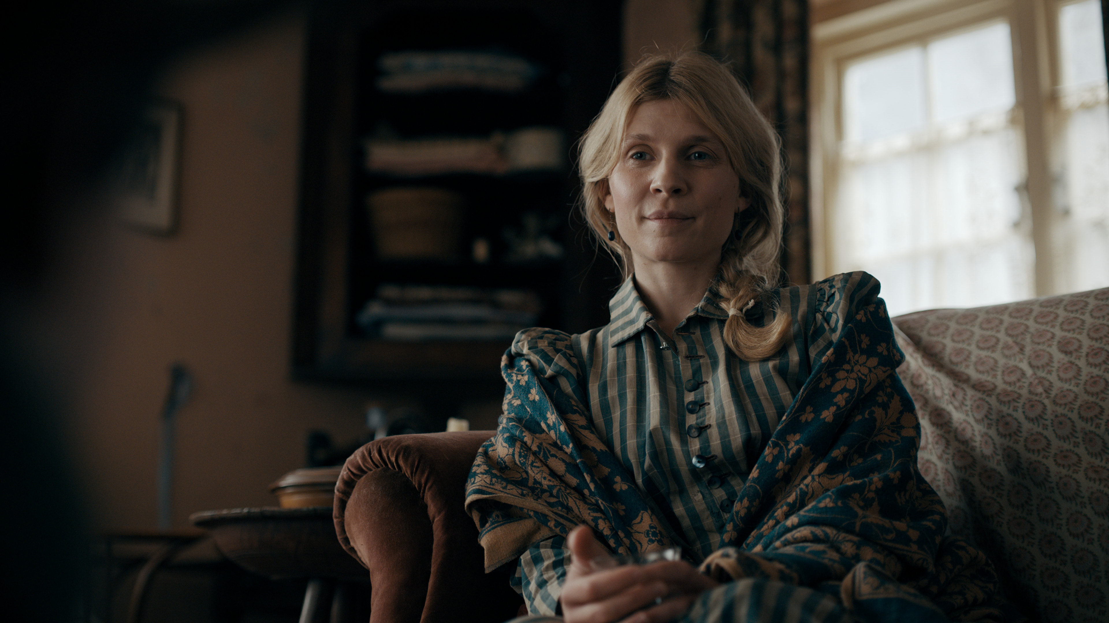 Clemence Poesy sitting on a couch in 'The Essex Serpent'