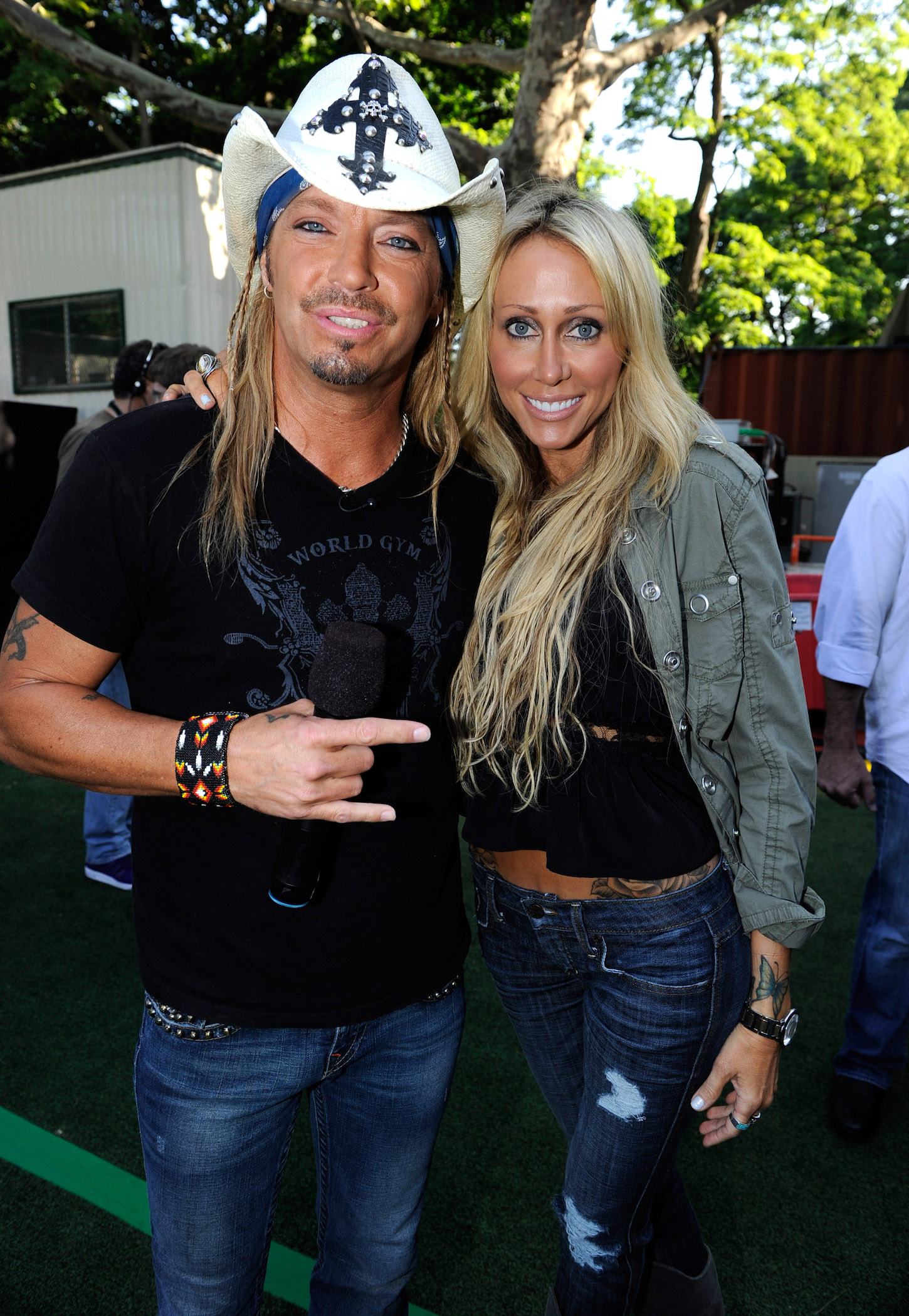 Bret Michaels and Tish Cyrus standing with their arms around each other and smiling for a photo