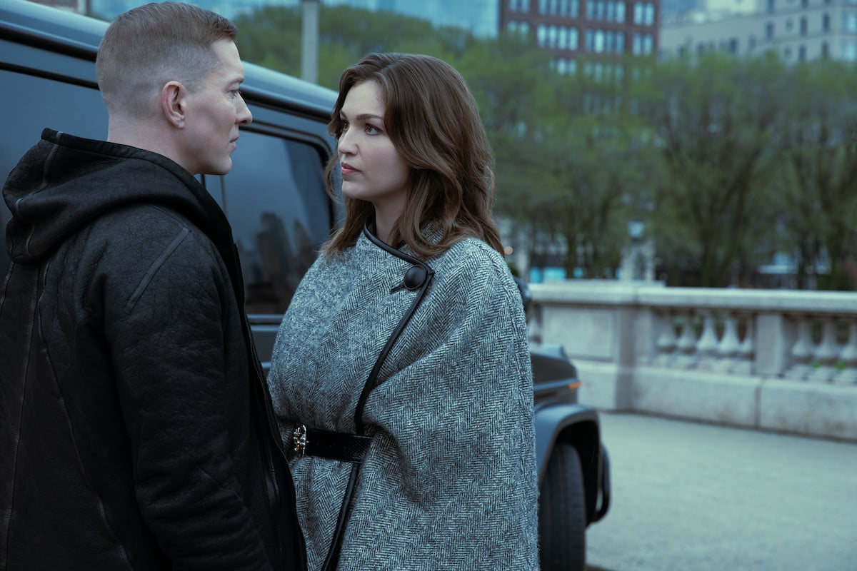 Tommy Egan and Claudia Flynn have a talk about business while standing outside near a truck in a scene from 'Power Book IV: Force' on Starz