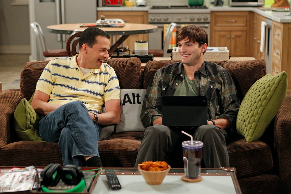 Jon Cryer and Ashton Kutcher laugh in a scene from Two and a Half Men