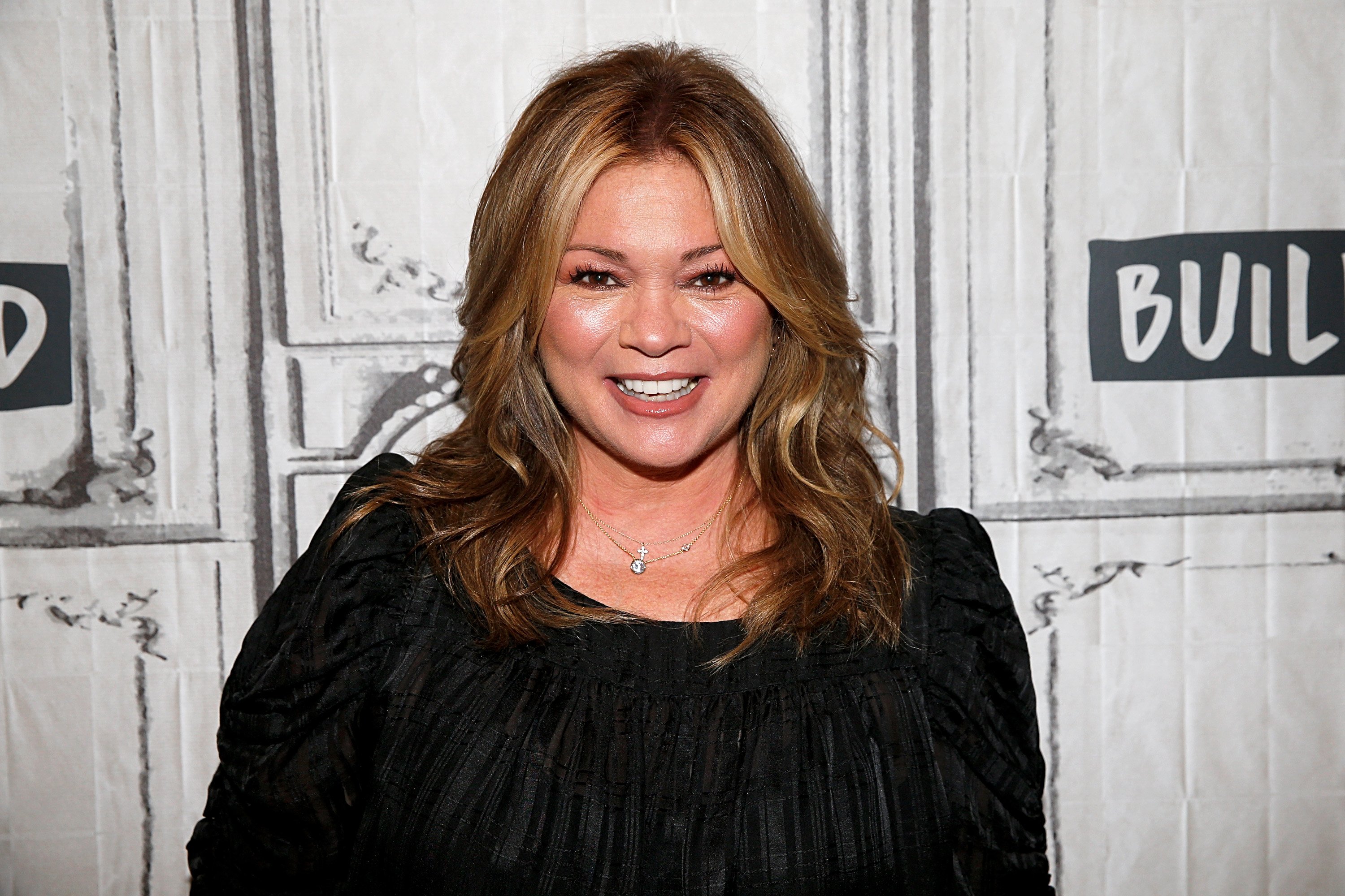 Food Network personality Valerie Bertinelli wears a long-sleeved black top in this photograph.
