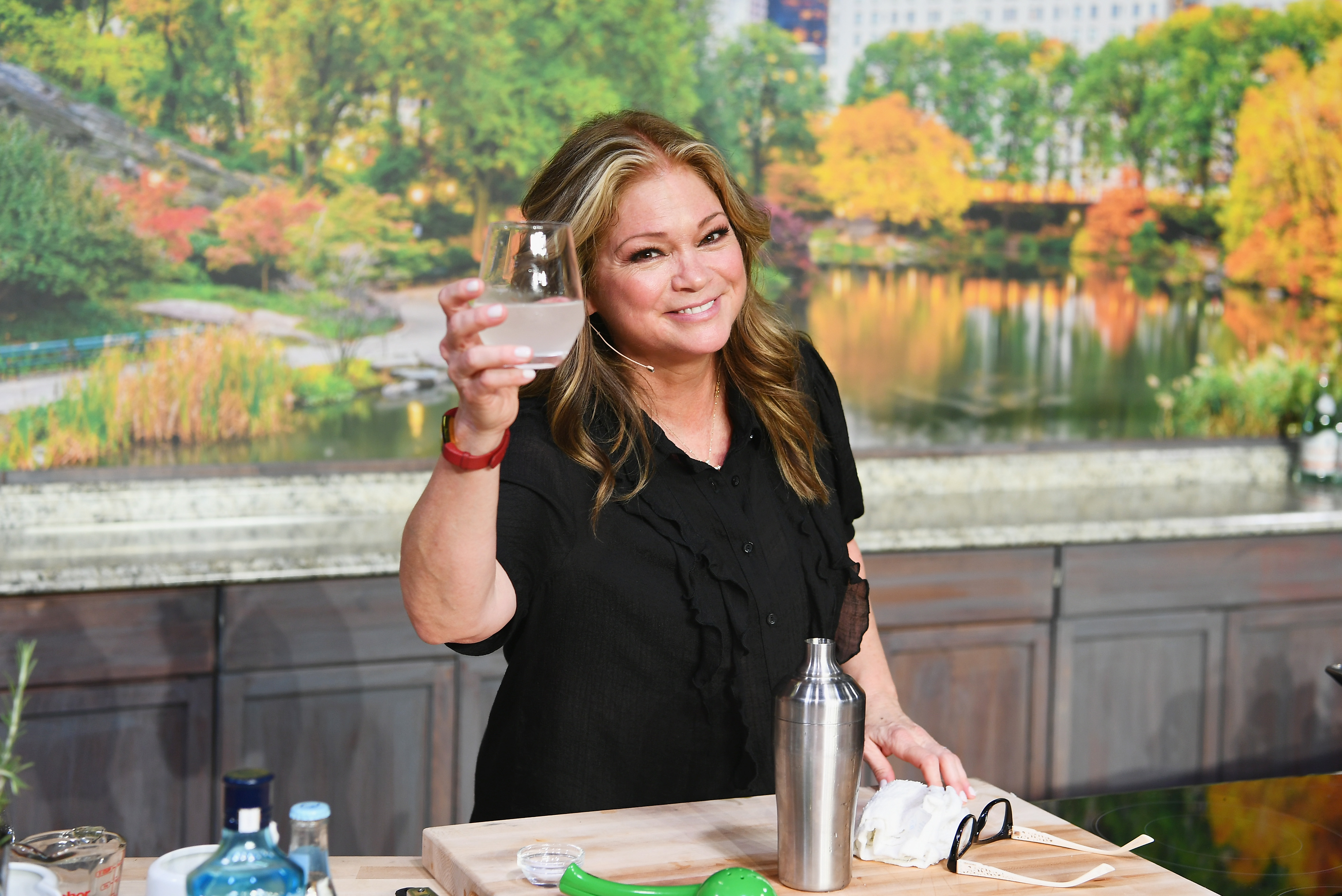 Food Network star Valerie Bertinelli wears a short-sleeve black top and raises a glass