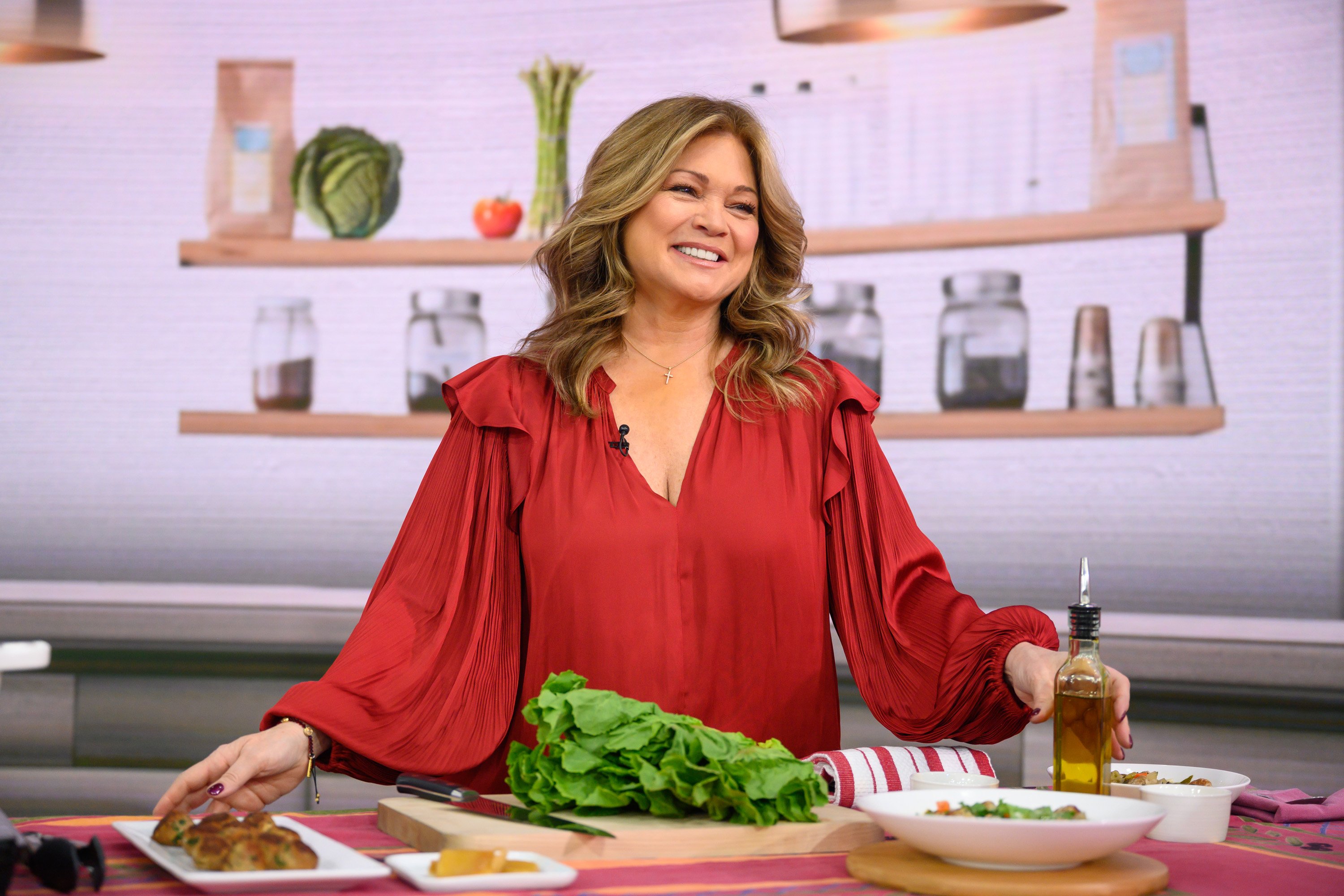 Food Network personality Valerie Bertinelli wears a red long-sleeved blouse in this photograph.