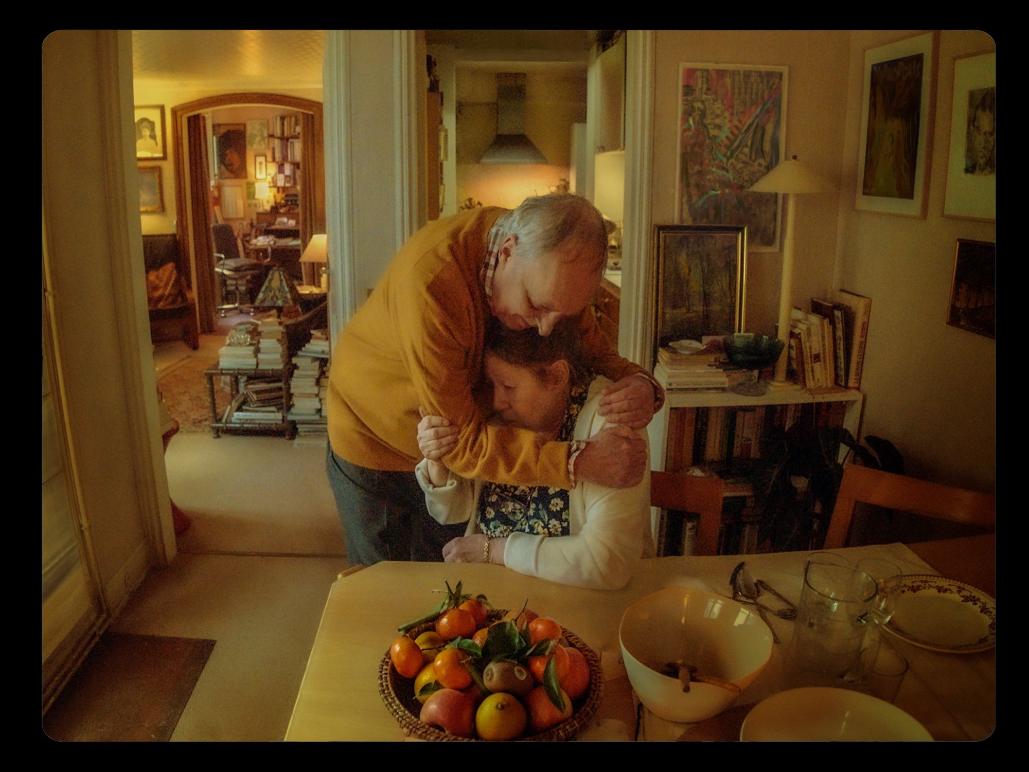 'Vortex' Dario Argento as Lui and Françoise Lebrun as Elle holding onto each other while Lebrun sits at the table