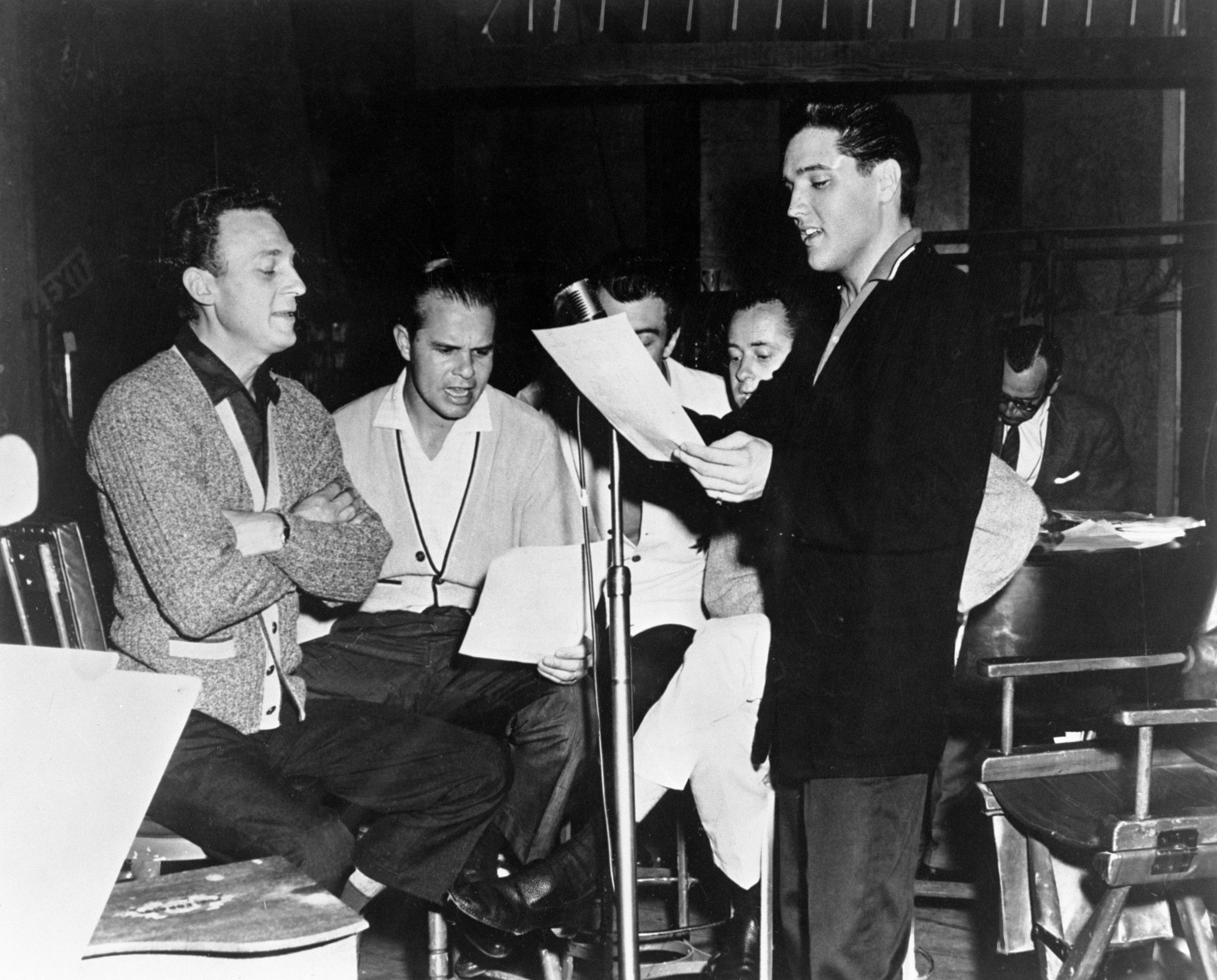 Elvis Presley near a microphone with The Jordanaires