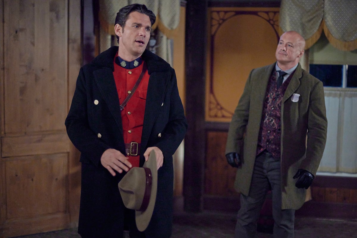 Nathan, holding his hat, standing next to Spurlock in 'When Calls the Heart' Season 9 Episode 9 