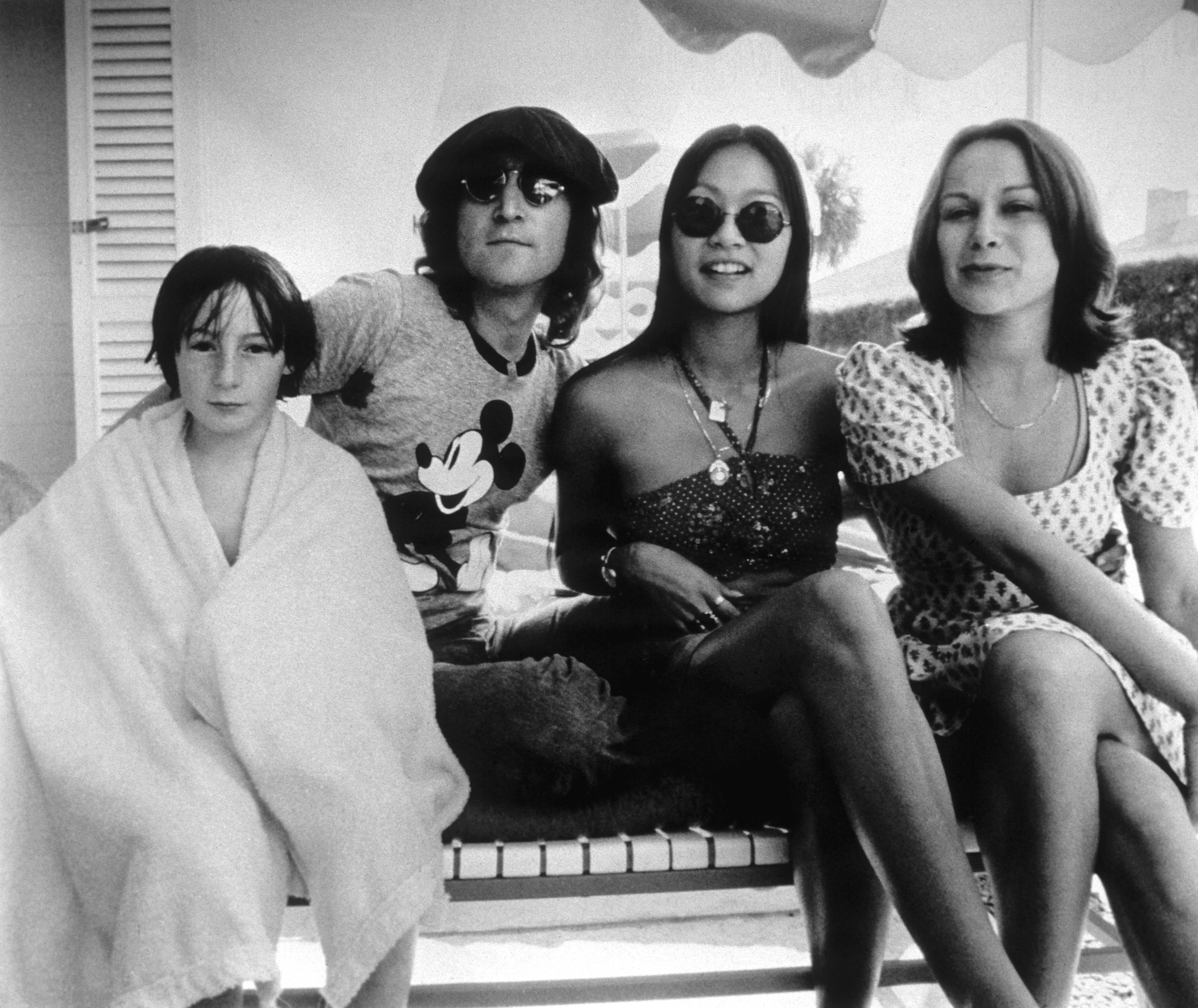 Julian Lennon, John Lennon, May Pang, and another woman on a seat