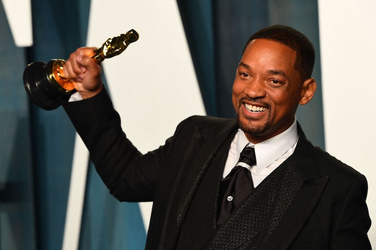 Will Smith smiles and holds up his Oscar