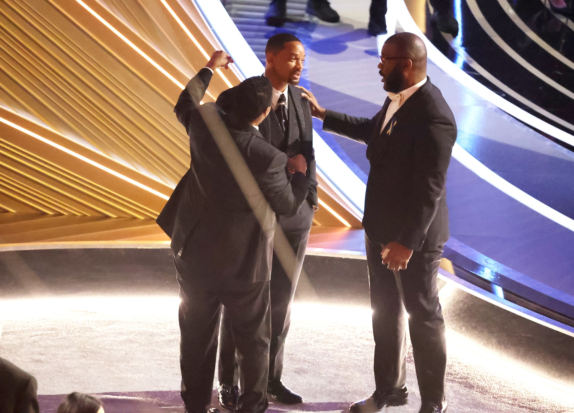 Denzel Washington and Tyler Perry talk to Will Smith after Smith charged the stage and slapped Chris Rock