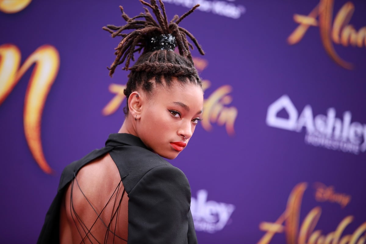 Willow Smith posing while wearing a black dress.