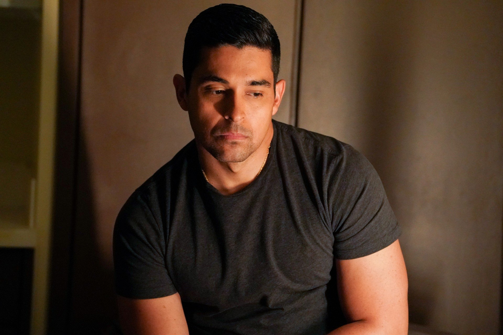 Wilmer Valderrama sits down and looks sad as he plays Nick Torres on NCIS. 