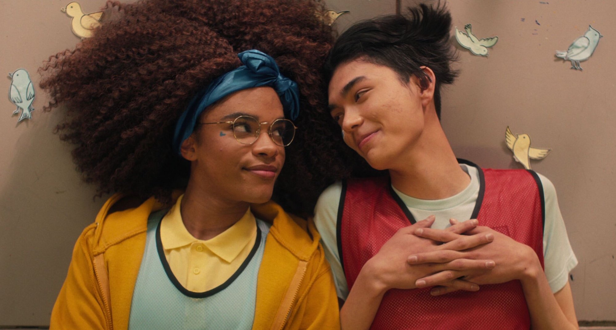Yasmin Finney and Will Gao from 'Heartstopper' sitting next to each other on the floor.