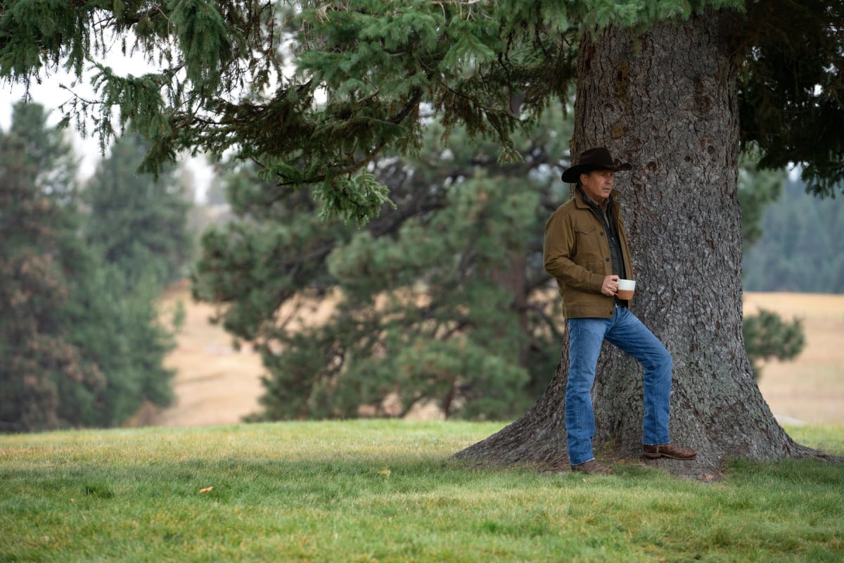 Kevin Costner poses under a tree as John Dutton on the Yellowstone ranch