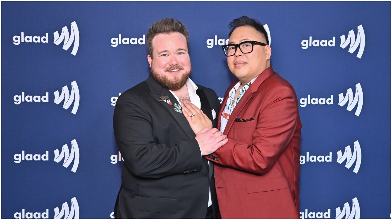 Zeke Smith and Nico Santos smiling and posing together at The 33rd Annual GLAAD Media Awards