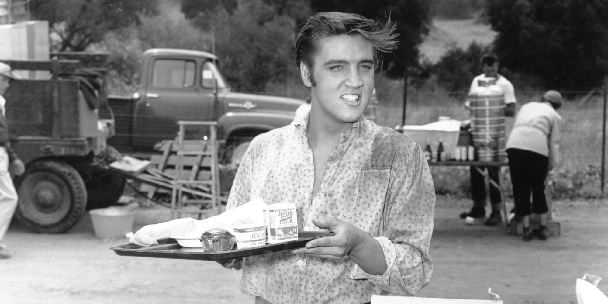 Elvis Presley holds a tray of food on the set of "Love Me Tender."