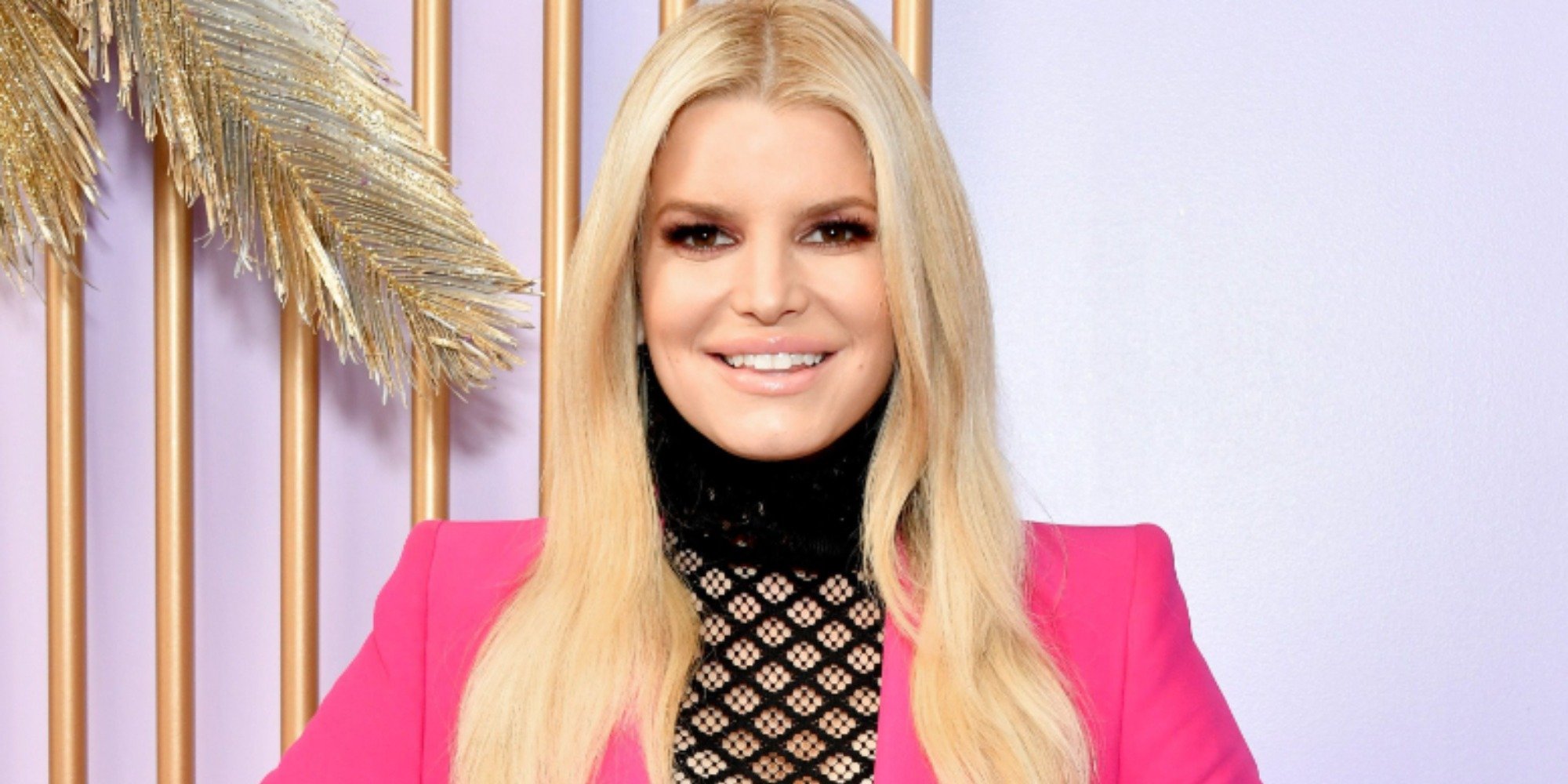 Jessica Simpson wears a pink jacket, oses for a photo in 2020.