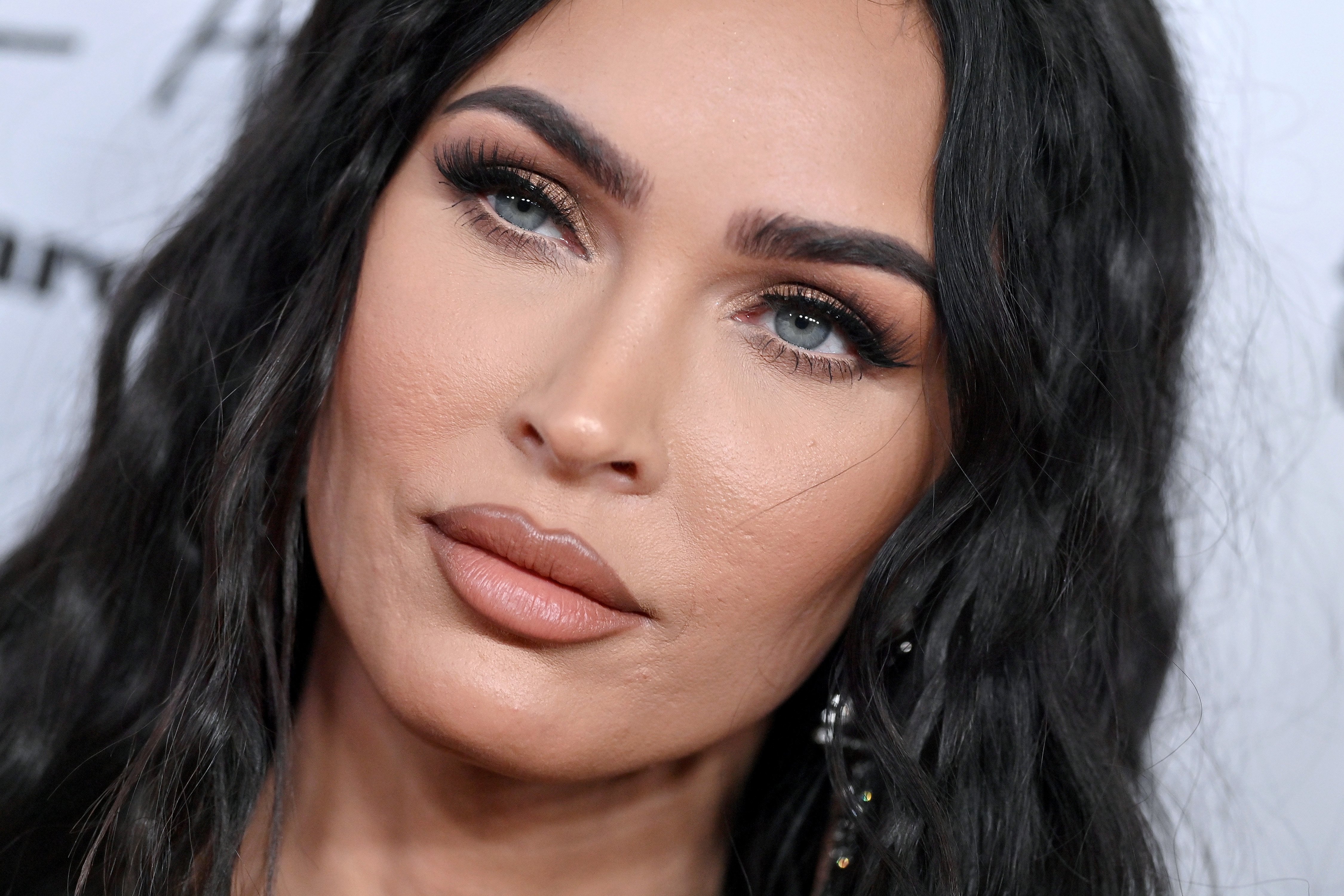 Megan Fox poses on the red carpet at an event.
