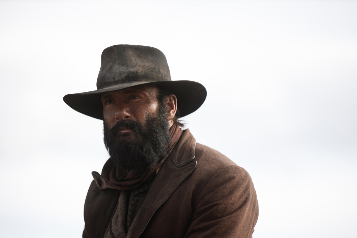 '1883' star Tim McGraw, son of Tug McGraw, wearing a brown hat and jacket in a scene from the show.
