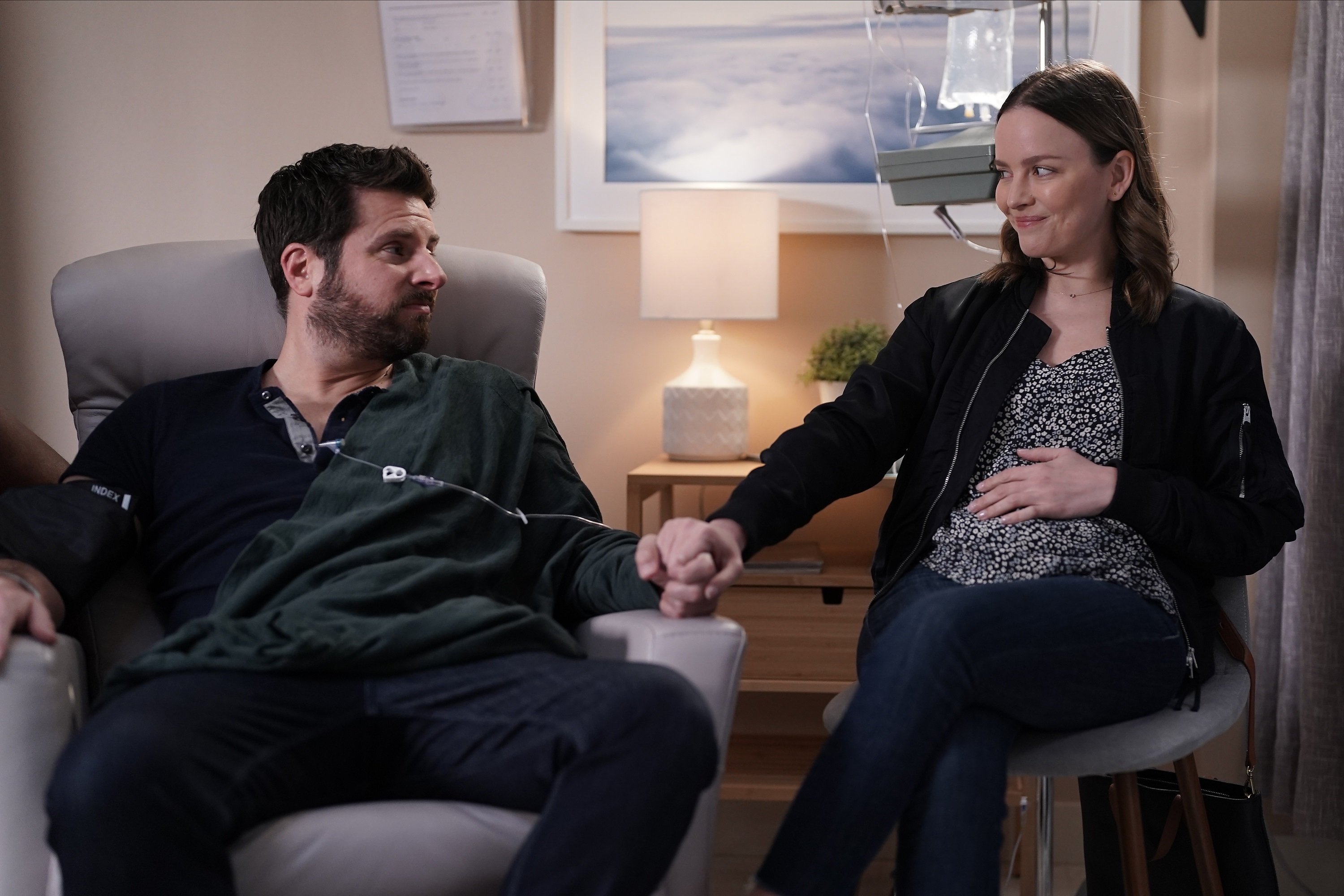 'A Million Little Things' James Roday Rodriguez as Gary and Allison Miller as Maggie Bloom sitting together holding hands while smiling