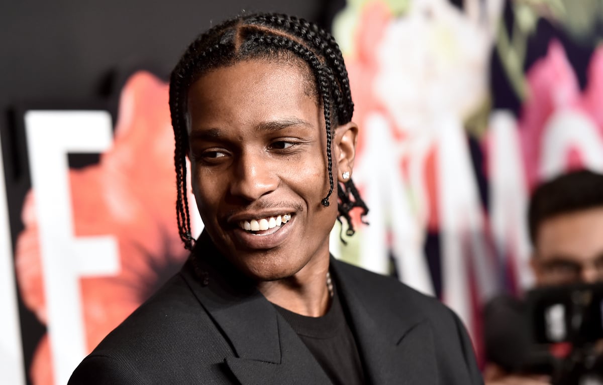 A$AP Rocky smiles while wearing a suit at an event