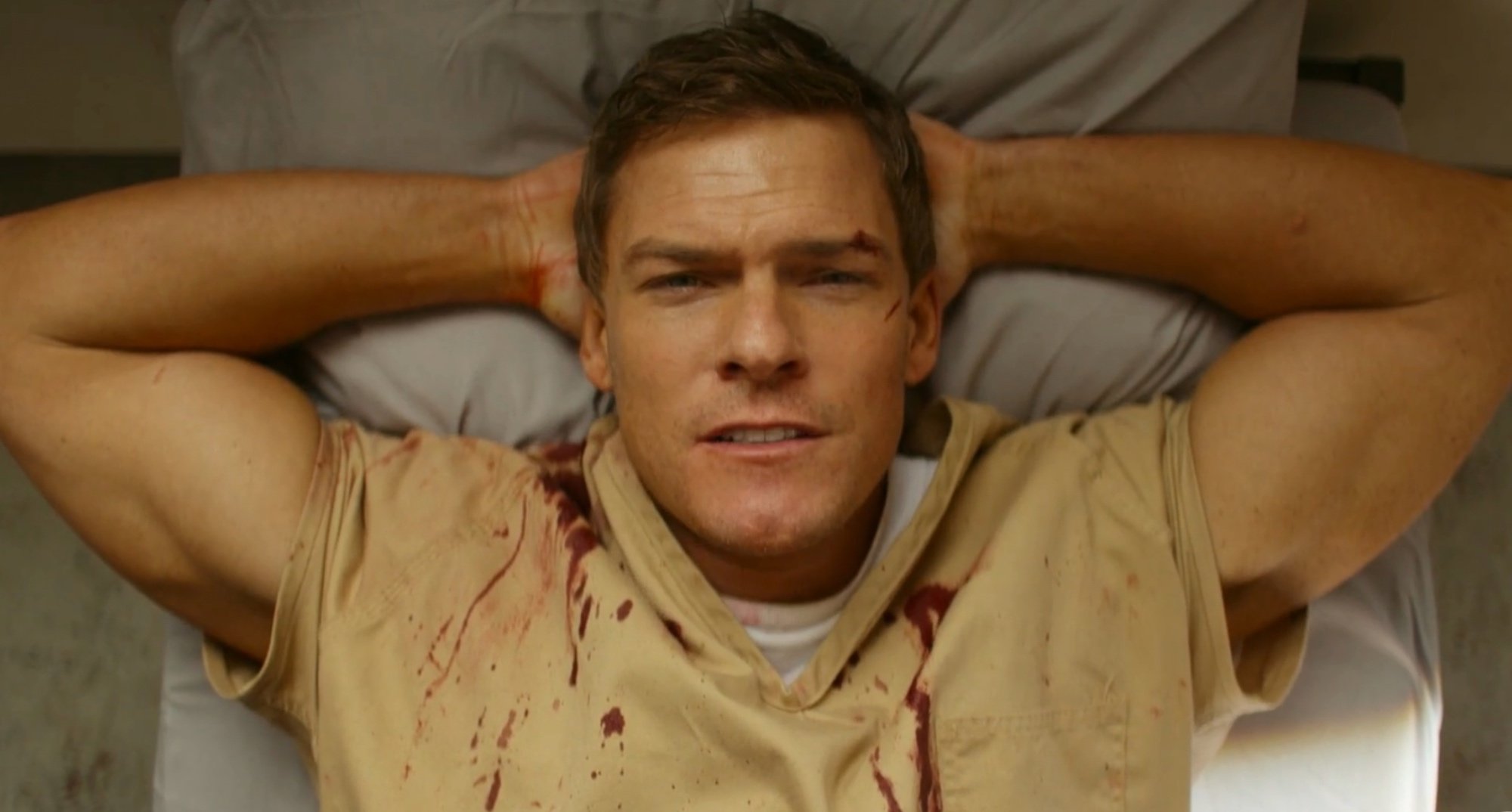 Alan Ritchson as Jack Reacher in 'Reacher' wearing prison clothes.