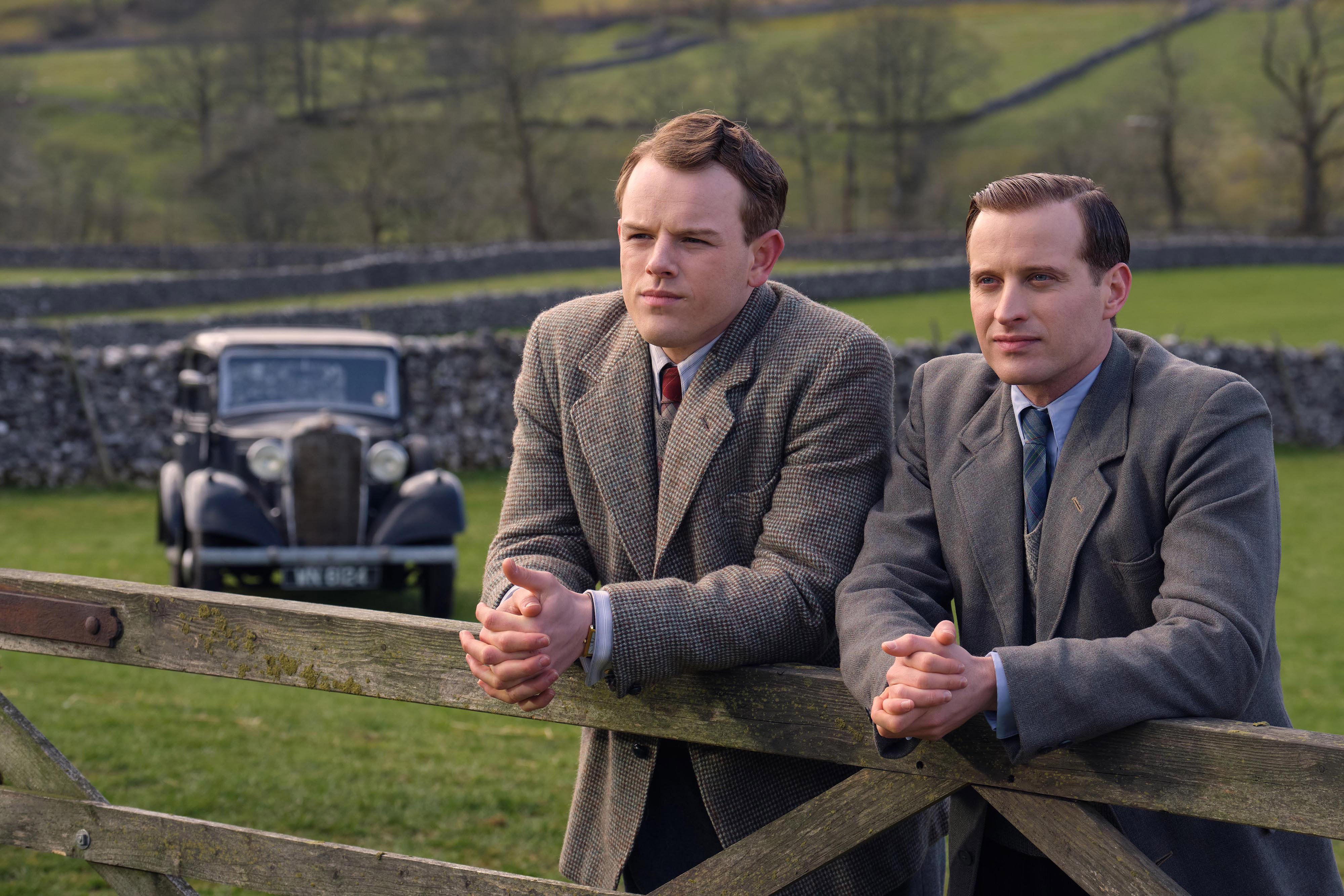 Tristan and James leaning on a fence in 'All Creatures Great and Small' Season 2