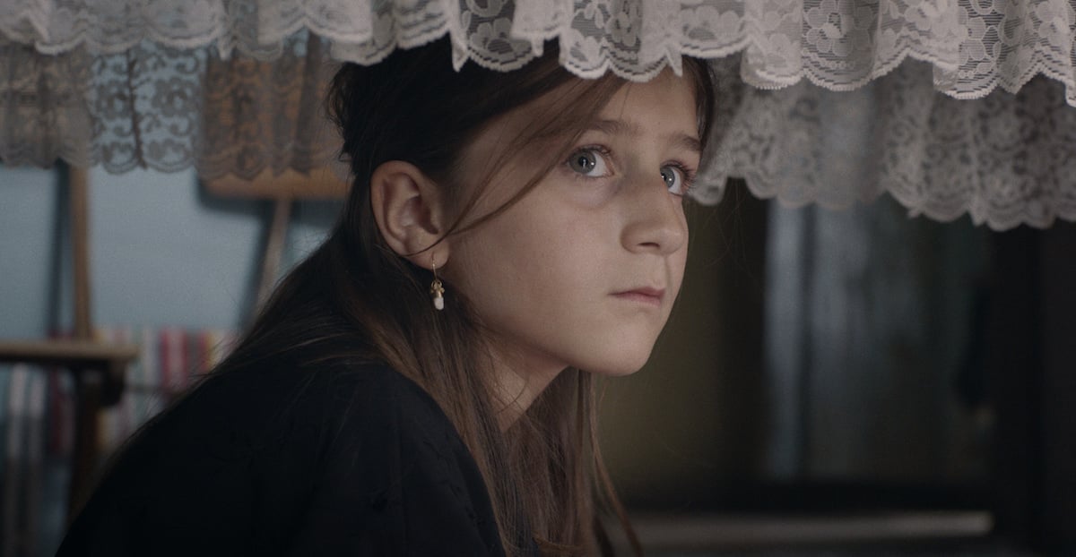 Lua Michel as Salomé sitting under her grandmother's casket in 'Alma Viva'