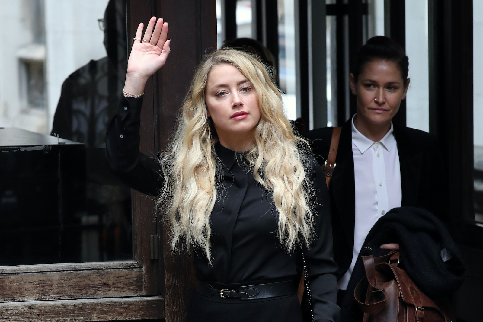 Amber Heard waves at fans outside a London courtroom 