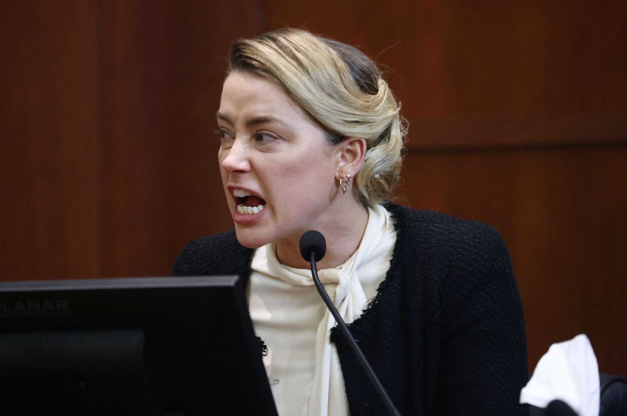 Amber Heard, seen here wearing a white shirt with a black sweater in court, was accused by Johnny Depp's lawyer of editing her photos.