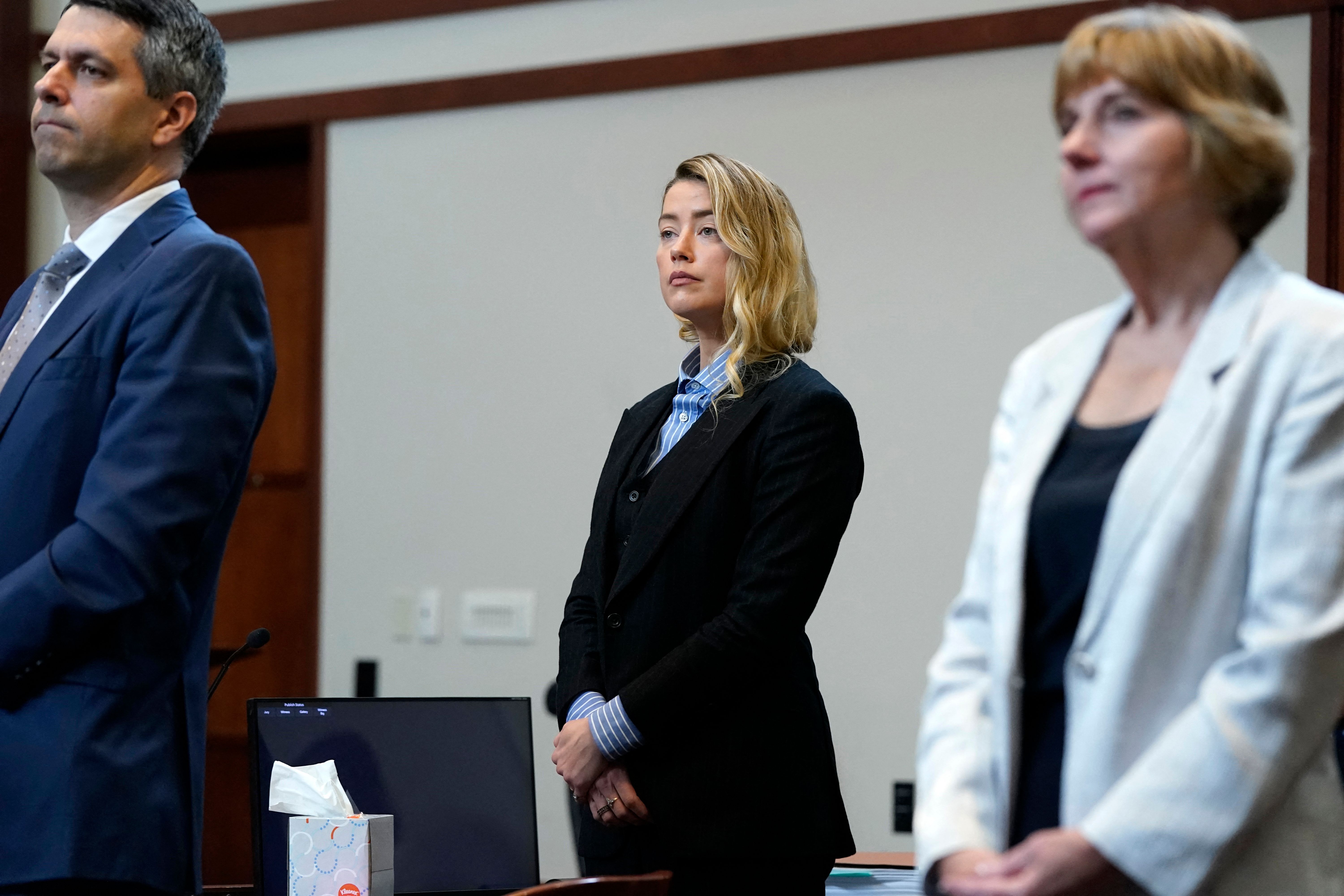 US actress Amber Heard (C) stands in the courtroom with her legal team at the Fairfax County Circuit Court, during a defamation case against her by ex-husband, US actor Johnny Depp, in Fairfax, Virginia, on May 4, 2022.