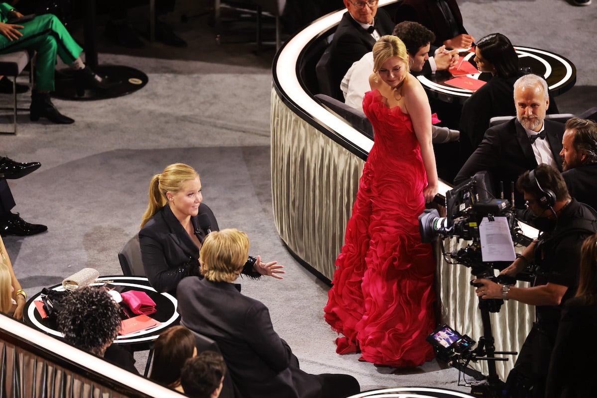 Co-host Amy Schumer performs a joke with Jesse Plemons and Kirsten Dunst at the 94th Annual Academy Awards