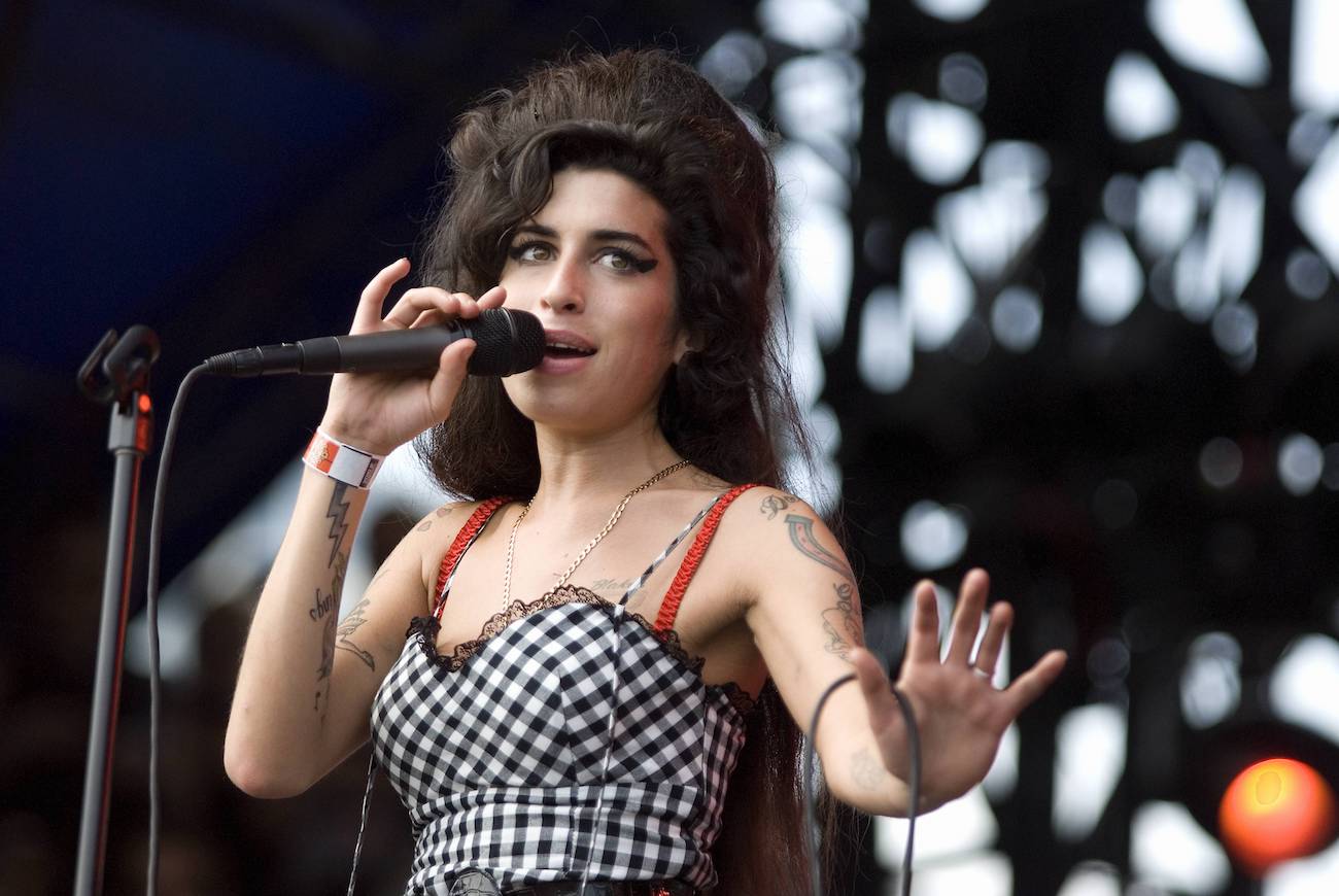 Amy Winehouse performing in a white and black dress in 2007.