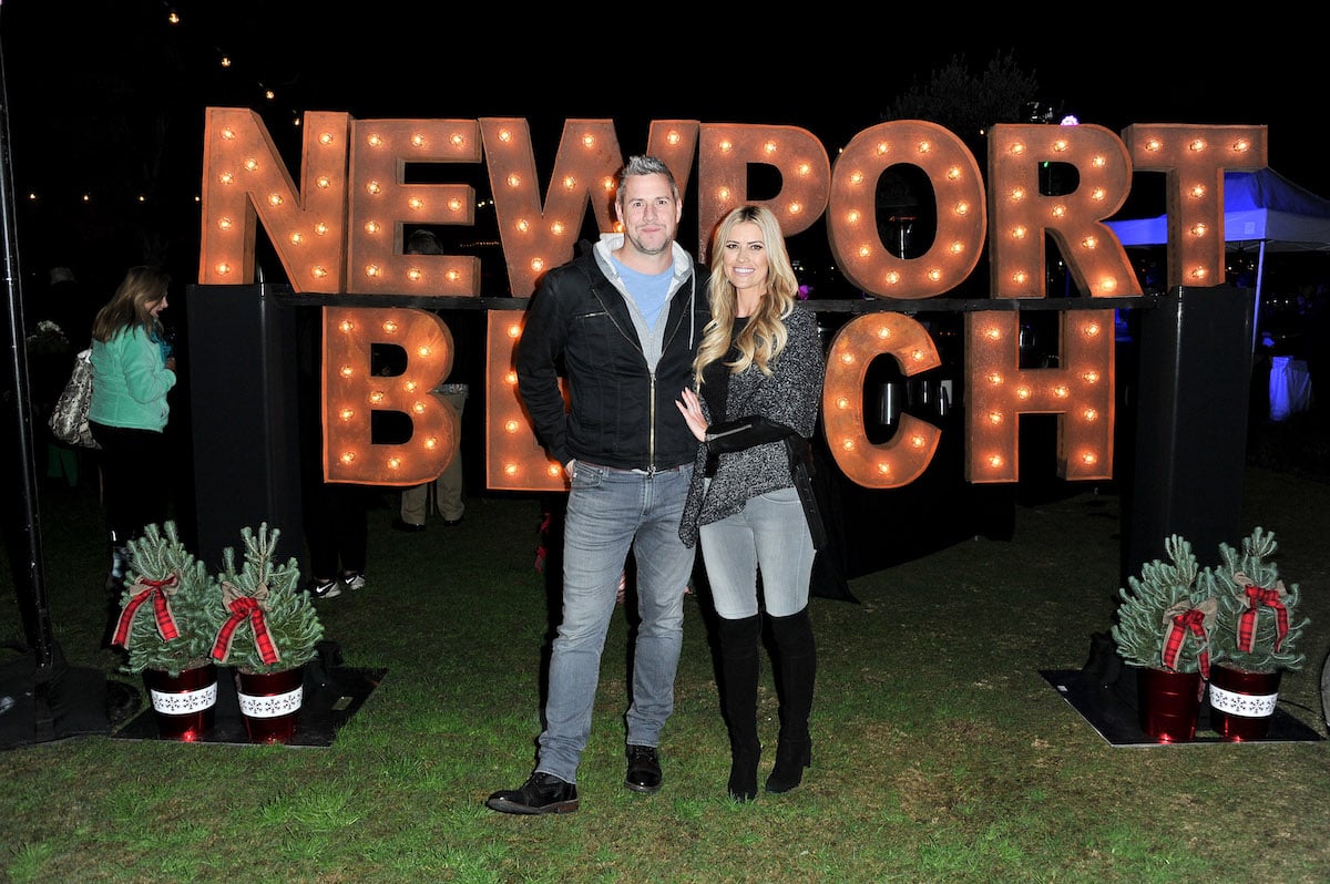 Ant Anstead and Christina Haack pose in front of a sign that says Newport Beach.