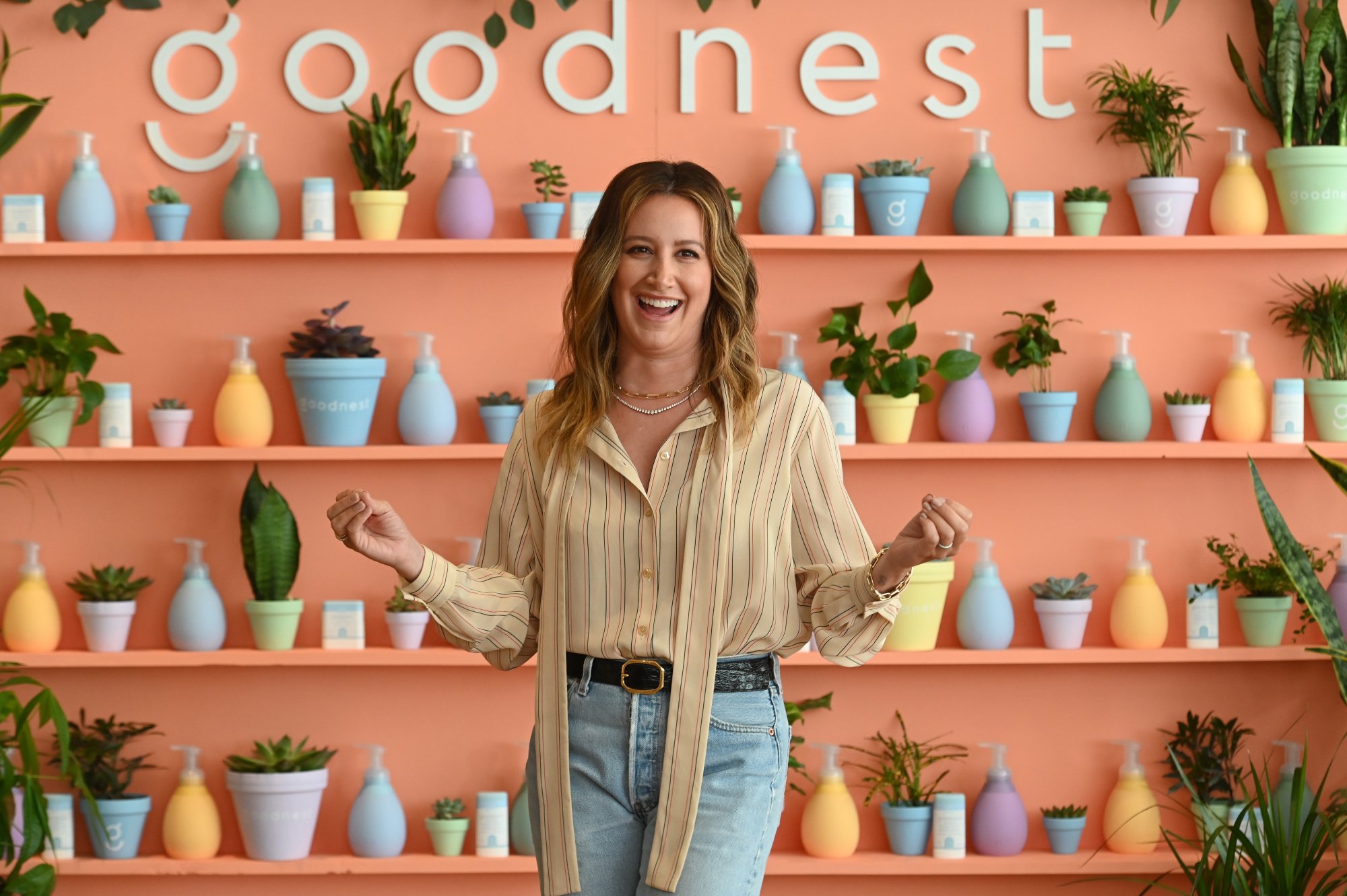 Ashley Tisdale, who did a tour of her Los Angeles home, smiling and standing in front of the Goodnest logo
