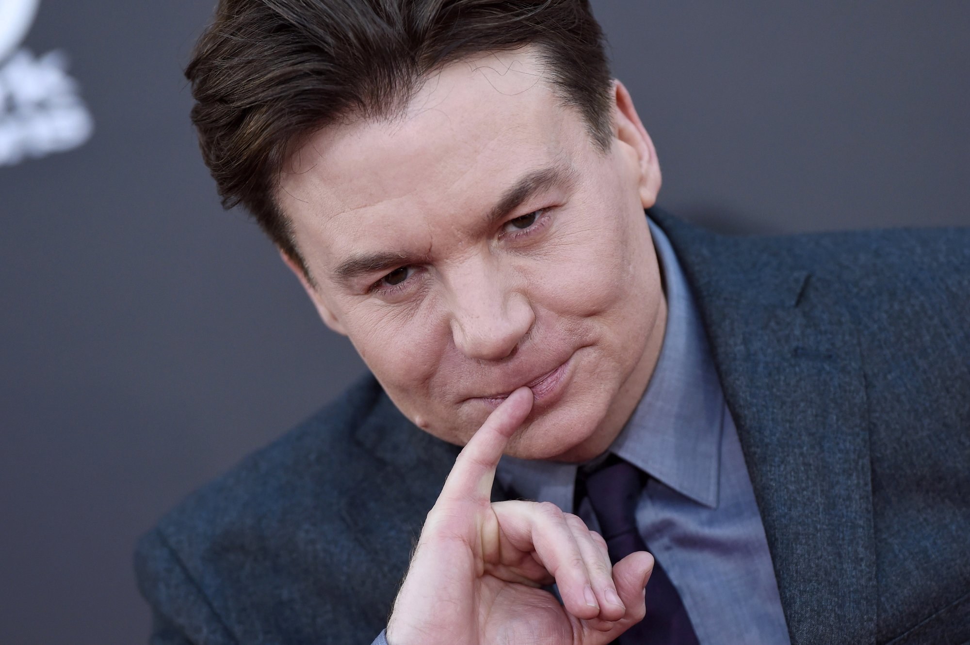 'Austin Powers 4' potential star Mike Myers holding his pinky up to his lips and wearing a suit