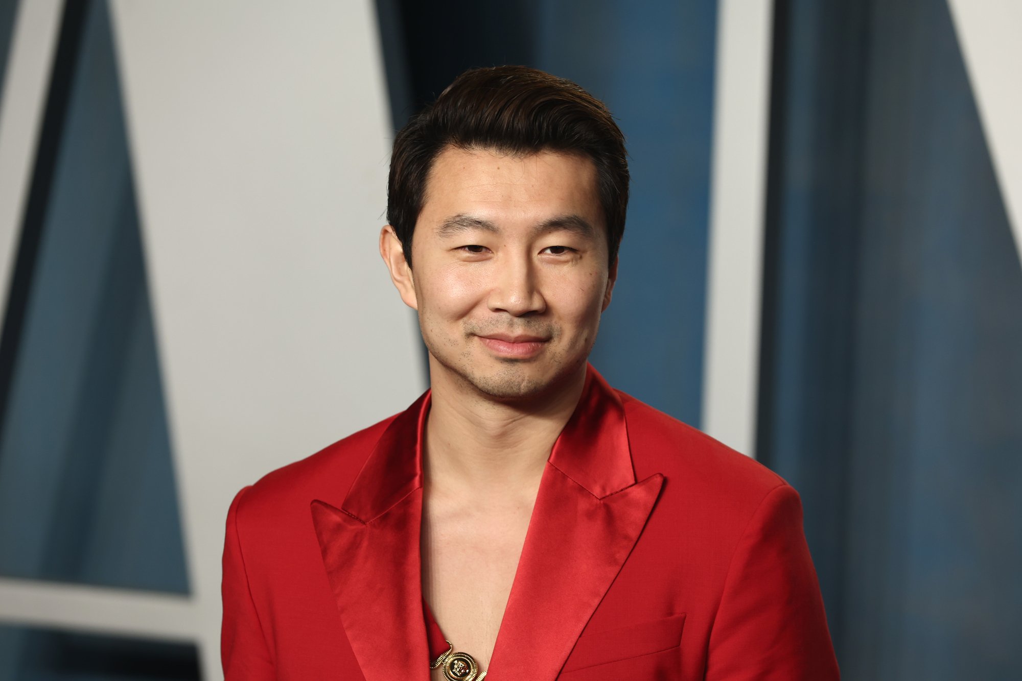'Barbie' actor Simu Liu wearing a red suit with a slight smile