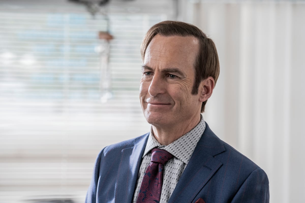 Saul Goodman wears a blue suit and red tie in Better Call Saul Season 6. 