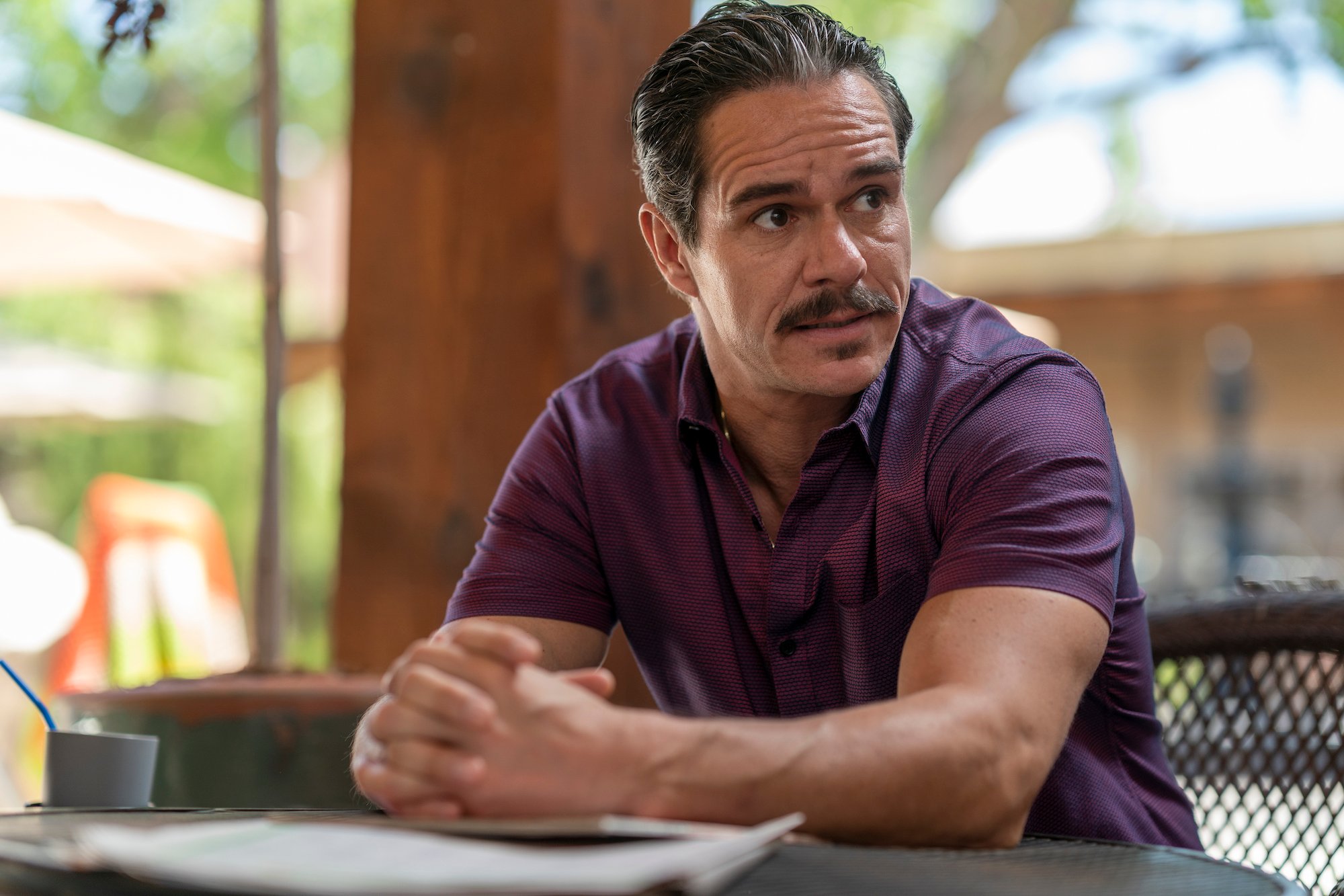 ‘Better Call Saul’ actor Tony Dalton as Lalo Salamanca with a mustache seated and wearing a purple shirt.